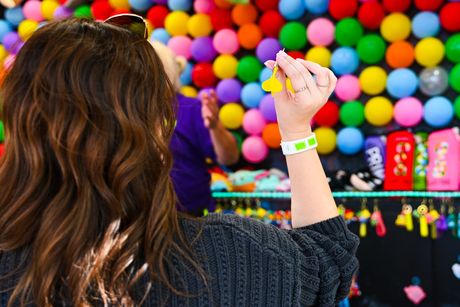 A woman is throwing a frisbee at a carnival.
