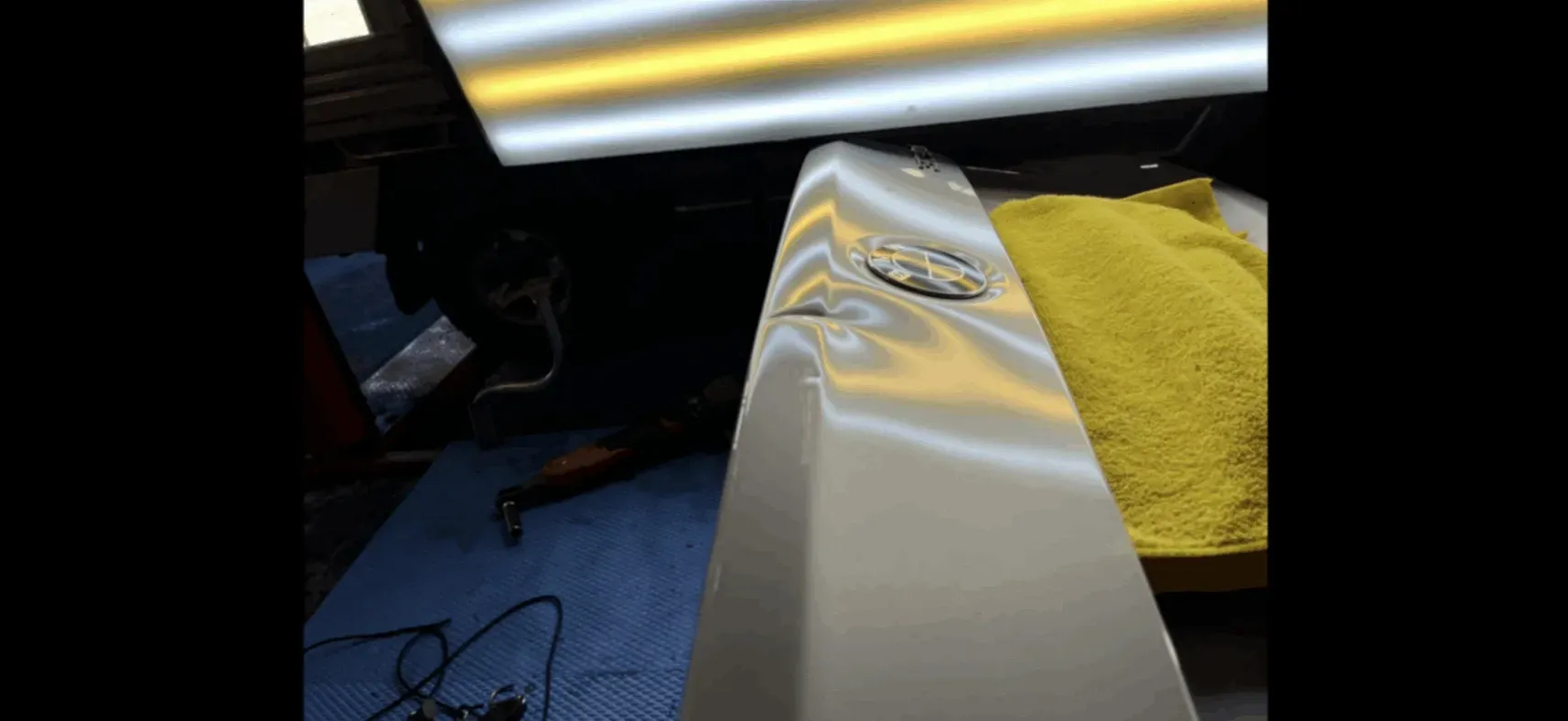 White couch with a yellow towel under bright overhead lights in a dim room