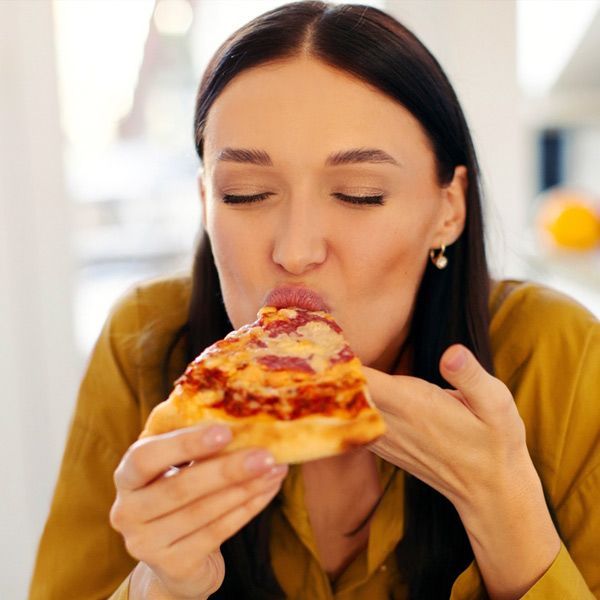 A woman with Insulin Resistance eating pizza during a food craving