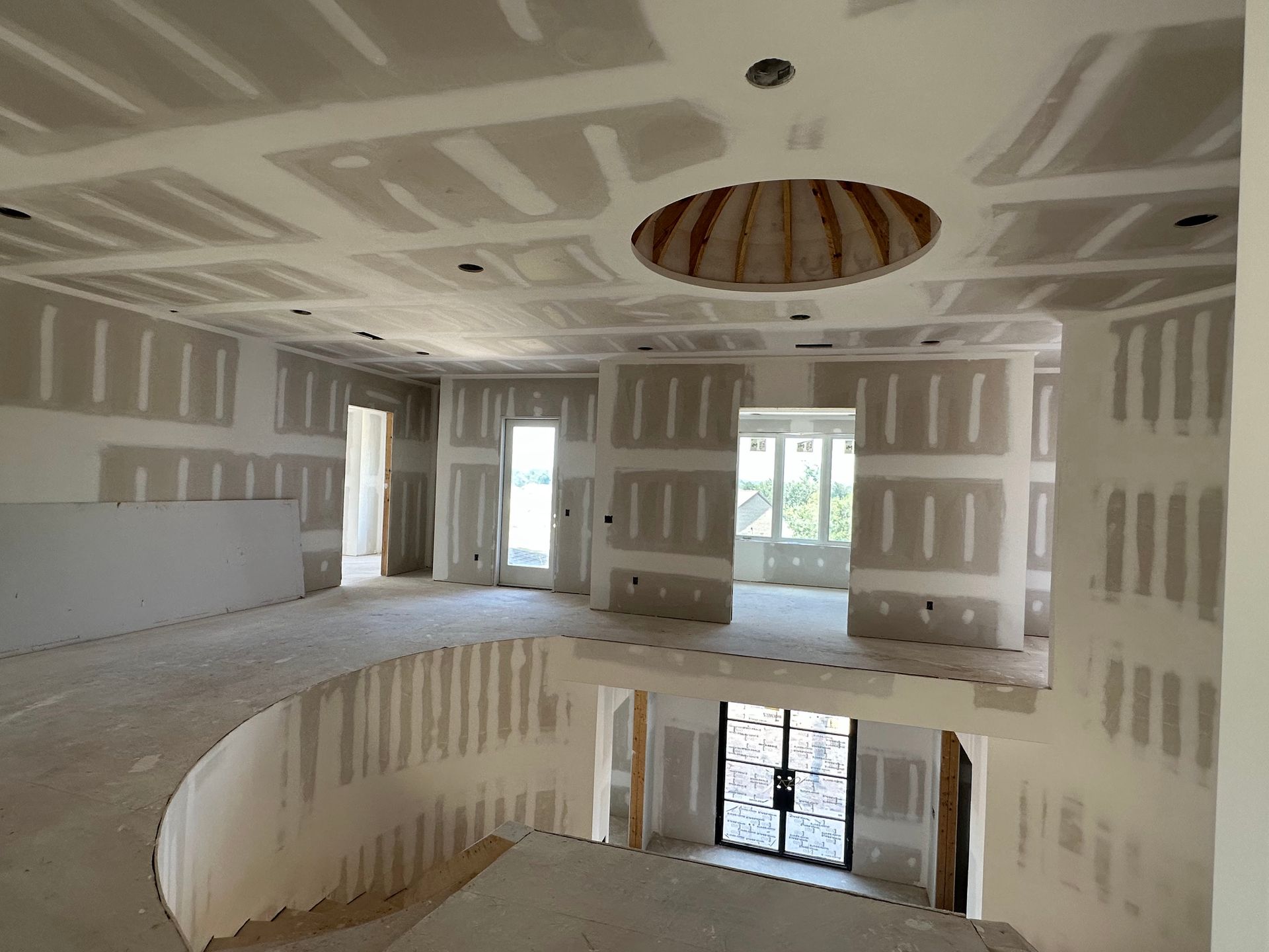 An empty room with a circular staircase in the middle