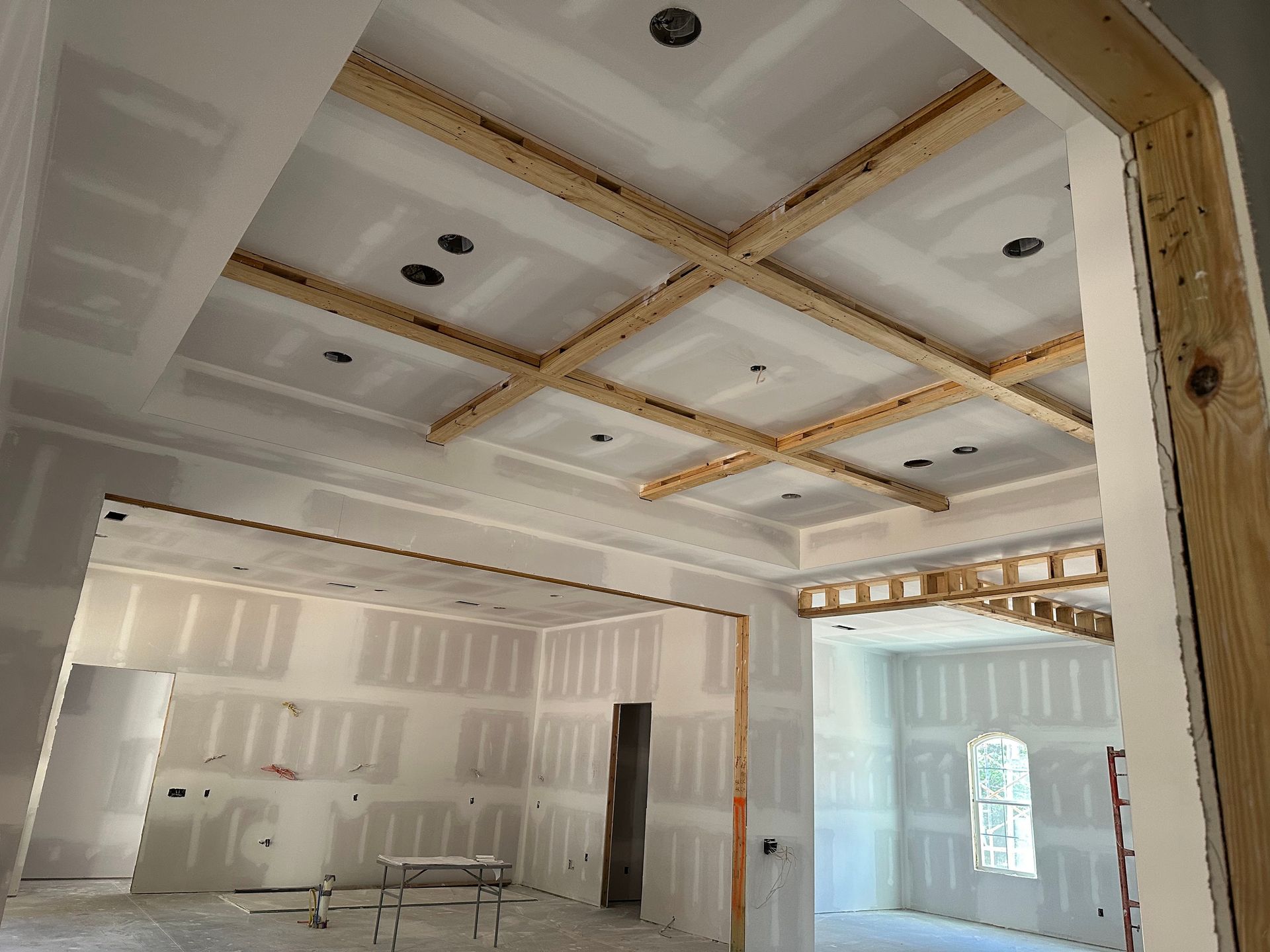 A room in a house under construction with a wooden ceiling.