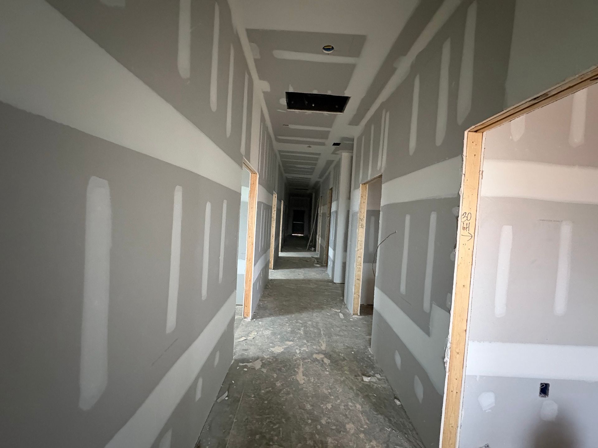 A long hallway with drywall on the walls