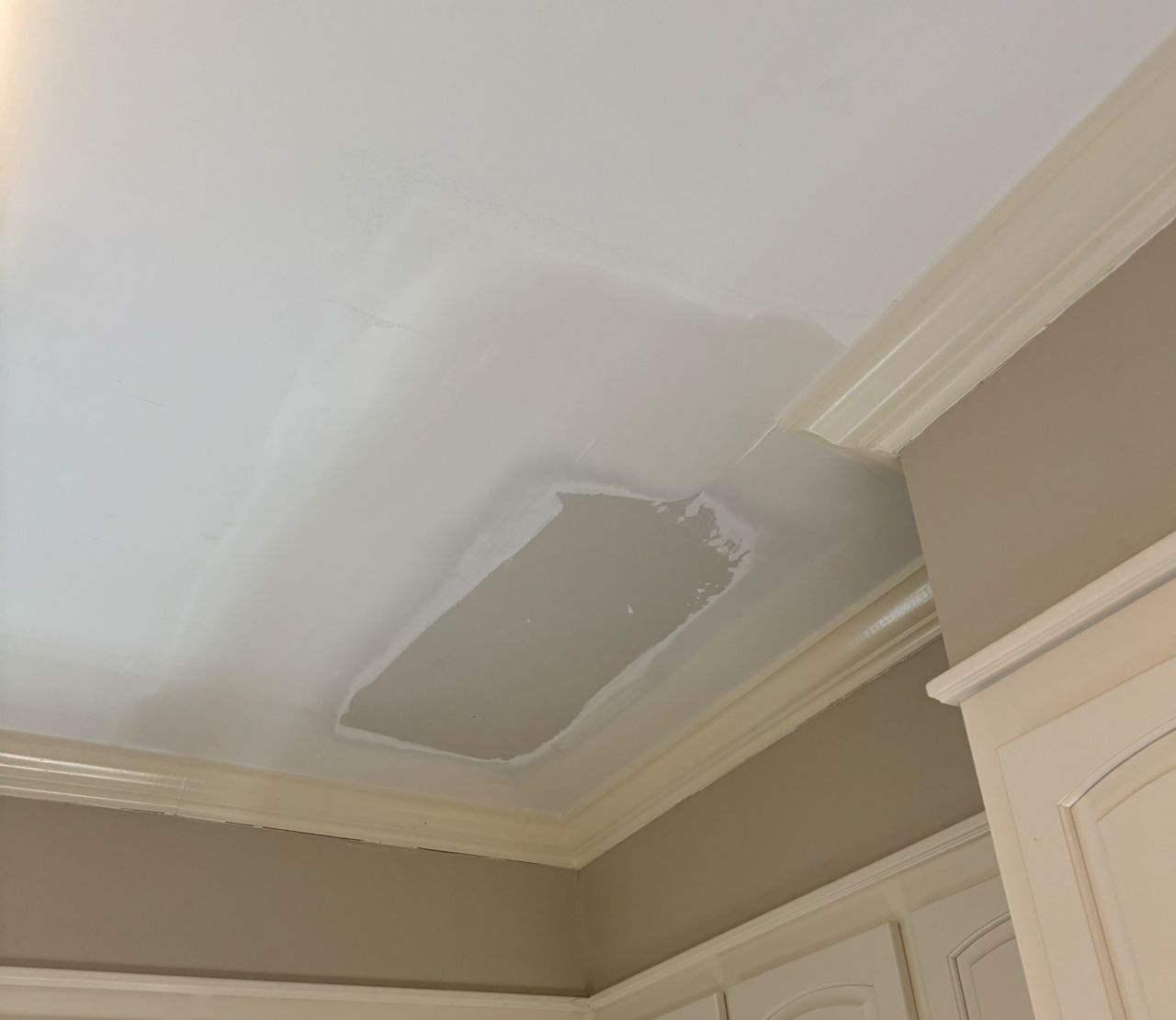 A white ceiling with a shadow of a bottle on it