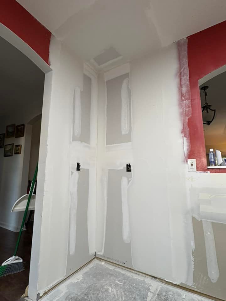 A room with white walls and red trim is being painted.