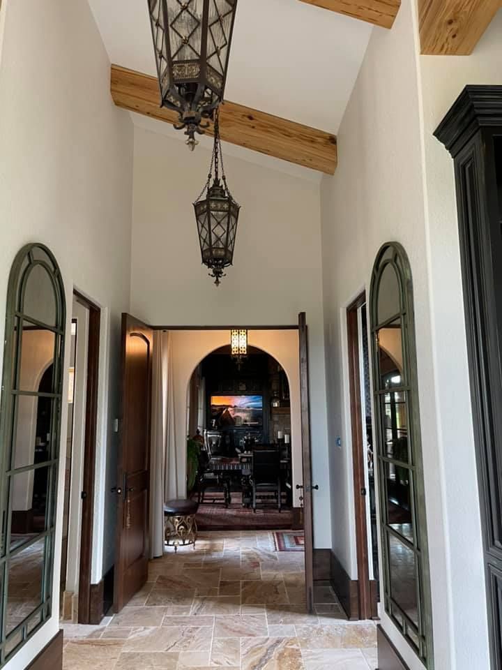 A hallway with mirrors and lanterns hanging from the ceiling