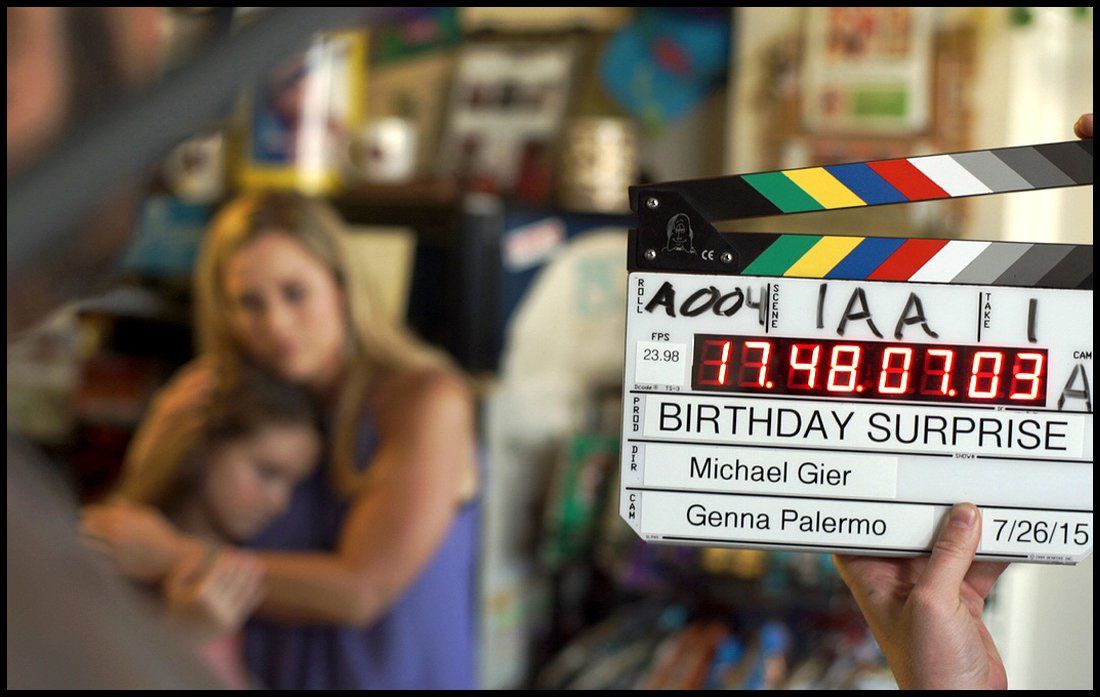 black woman with a production slate in front of her