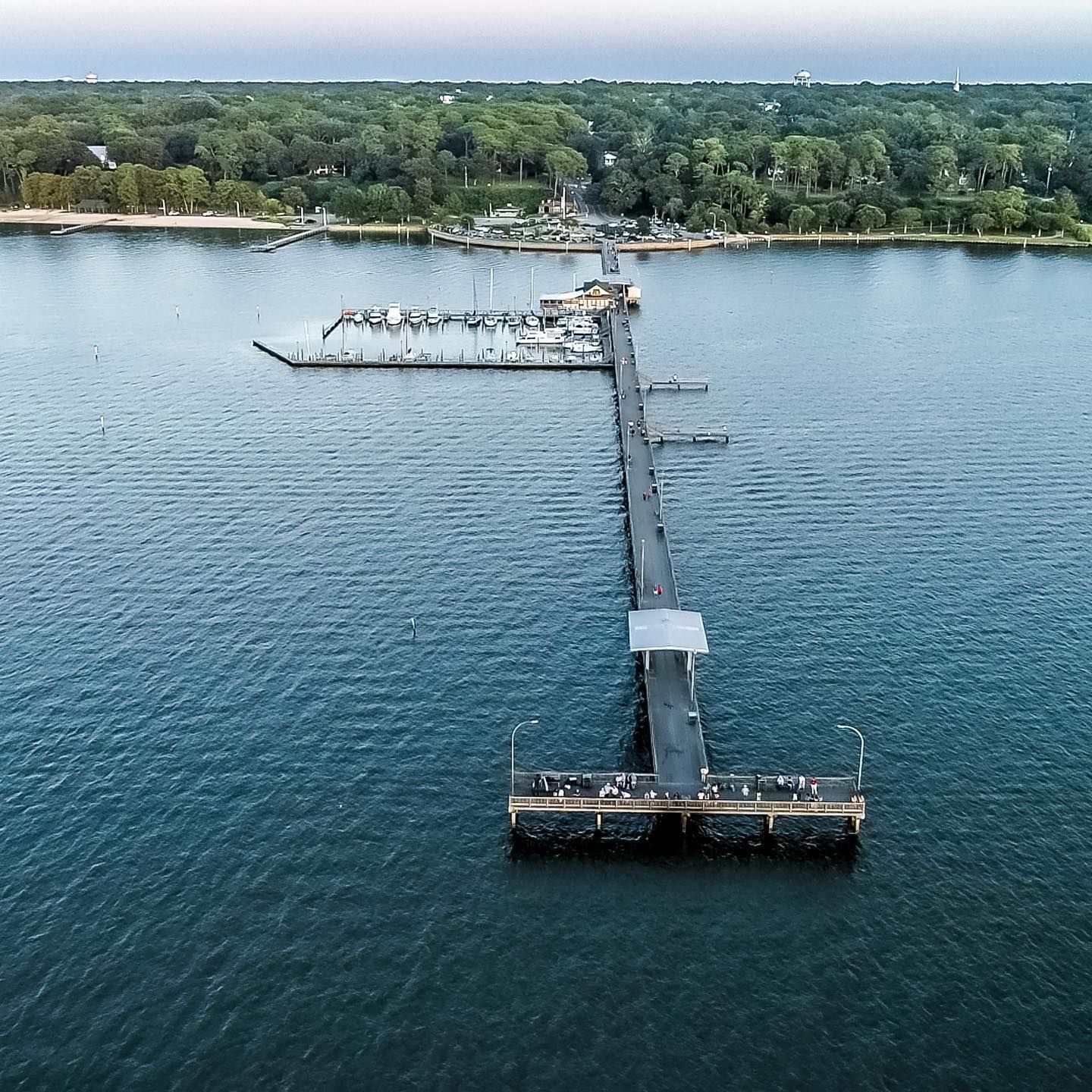 An aerial view of a pier in the middle of a body of water