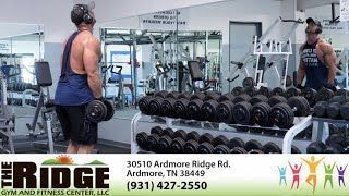 A man is lifting dumbbells in a gym .
