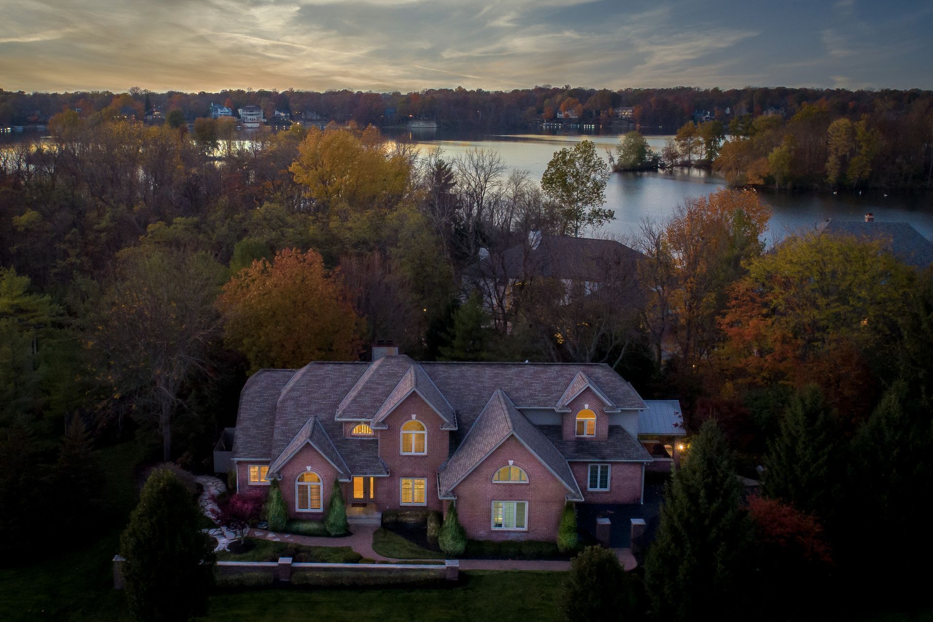 An aerial view of a house with a lake in the background