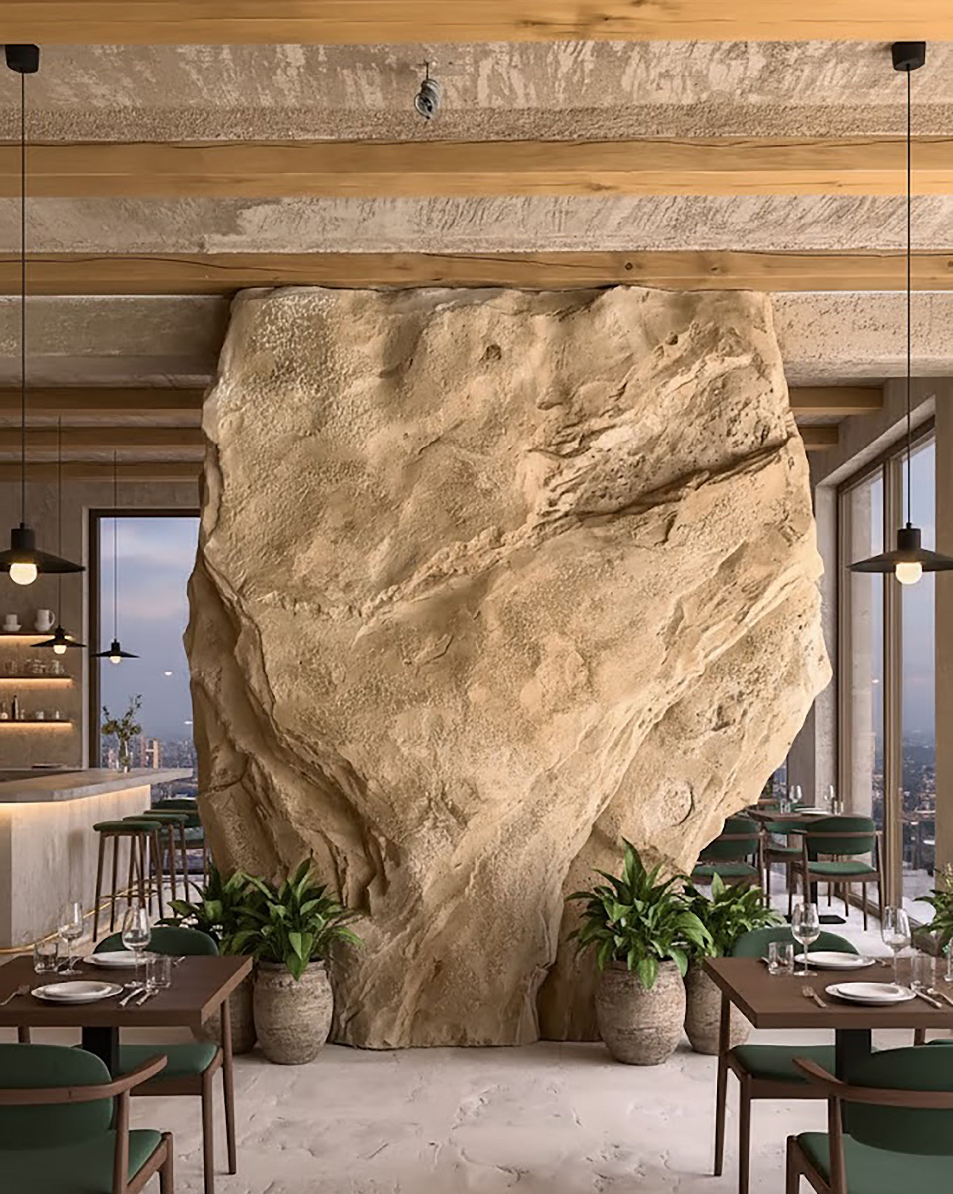 Interior de restaurante con una gran formación rocosa. Mesas, sillas, plantas y ventanas con vistas a la ciudad.