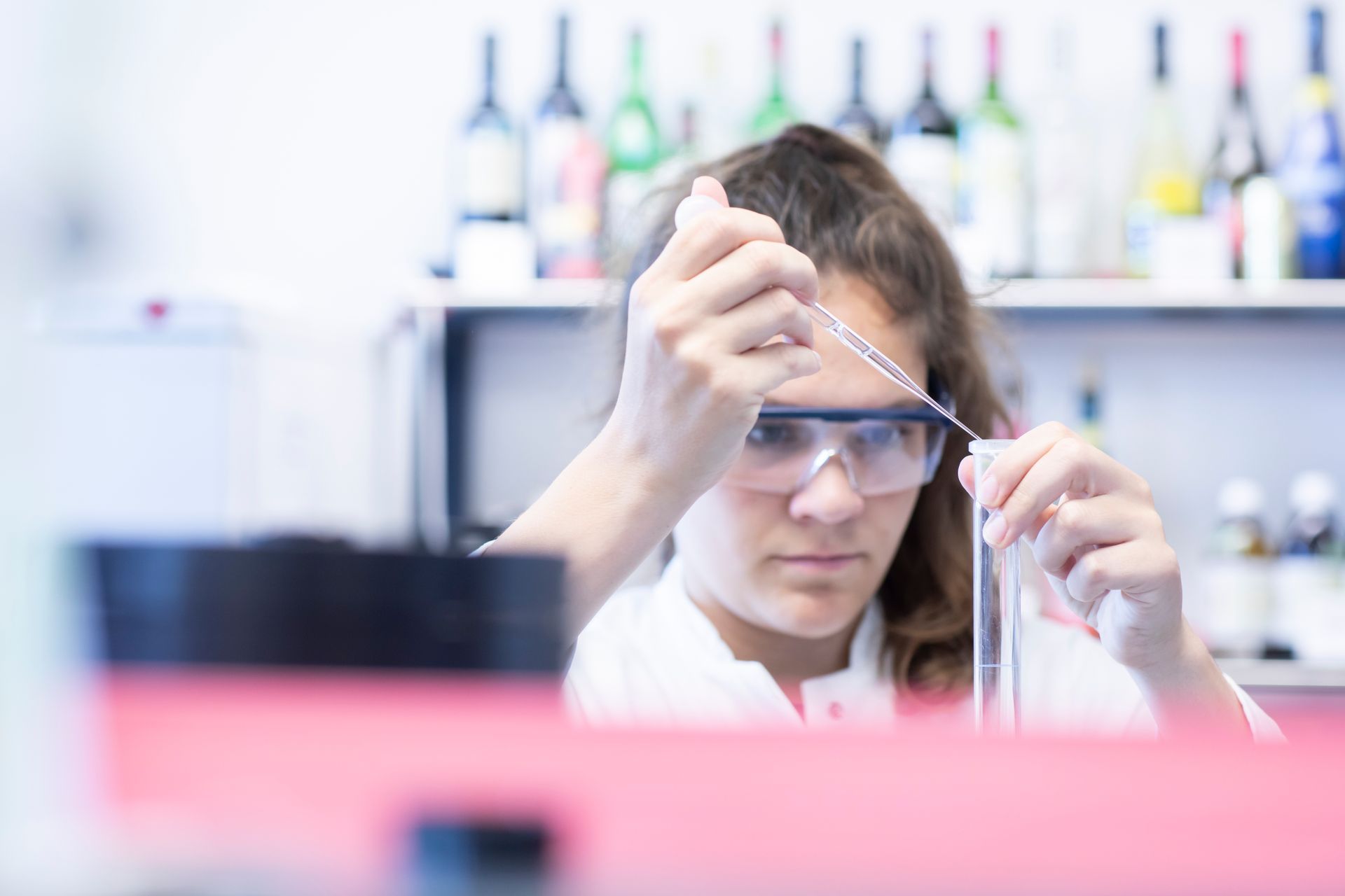 Eine Chemielaborantin pipettiert eine Flüssigkeit