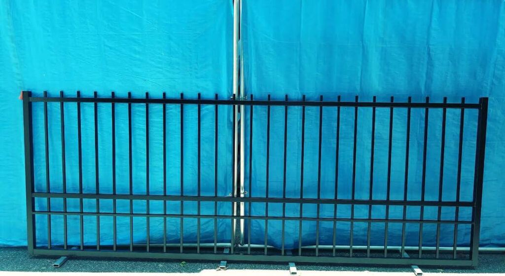 A metal fence is sitting in front of a blue wall