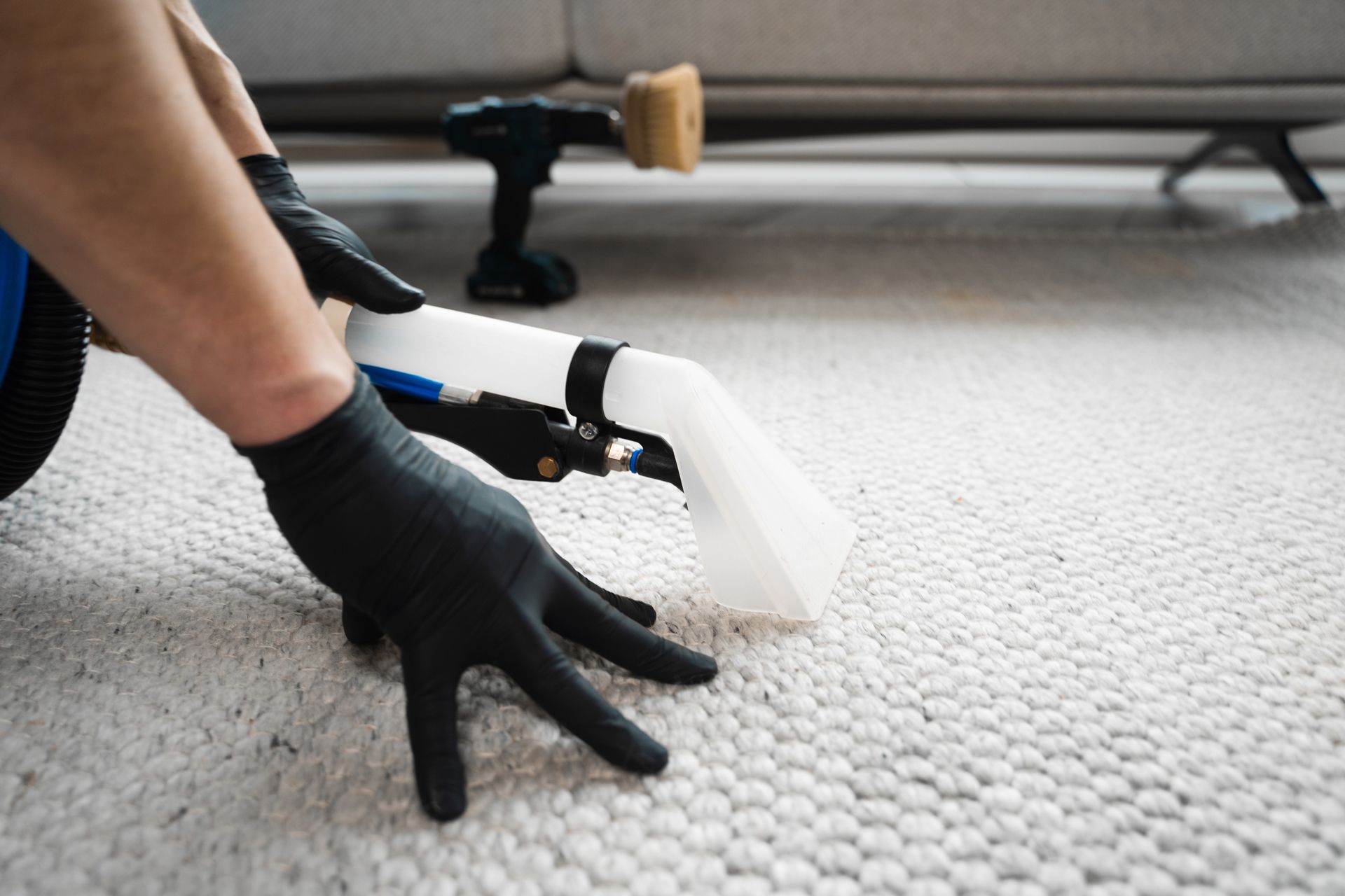 A Person is Cleaning a Carpet With a Vacuum Cleaner