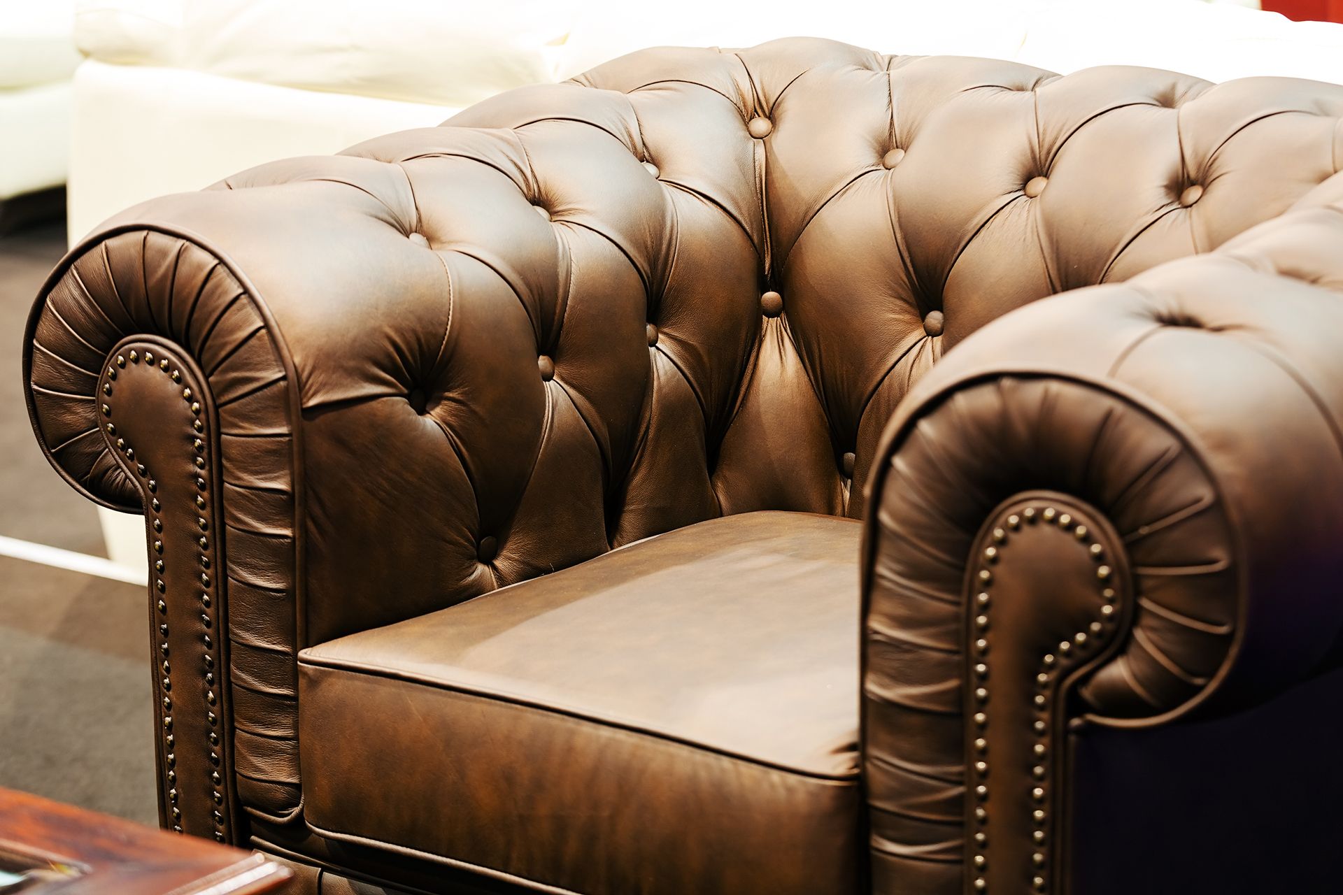 A brown leather chair is sitting next to a wooden table.