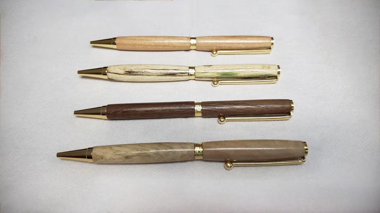 Four vintage fountain pens arranged horizontally on a light background