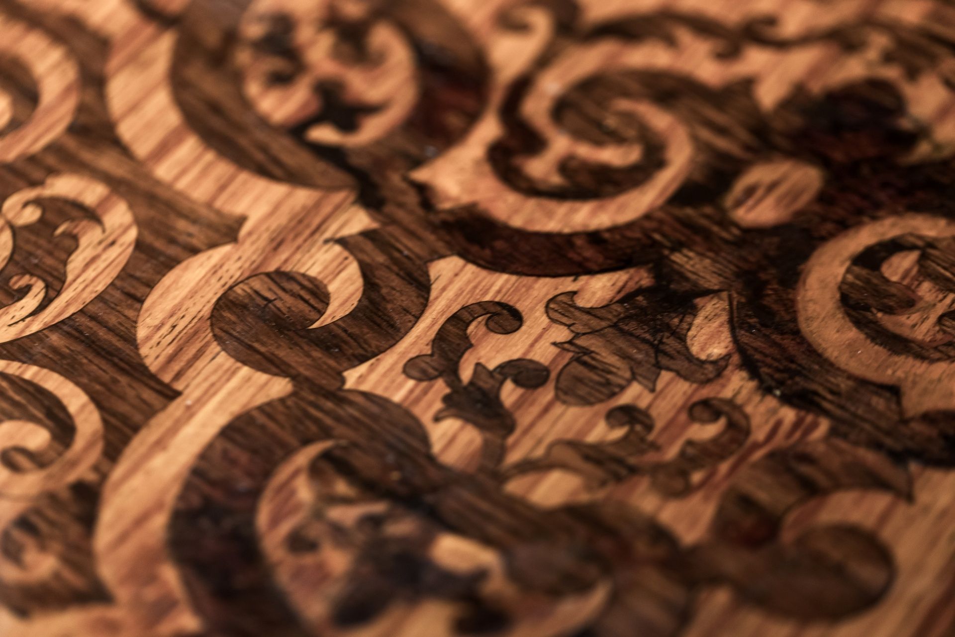 Close-up of carved wooden ornamental scrollwork with warm brown tones and intricate patterns