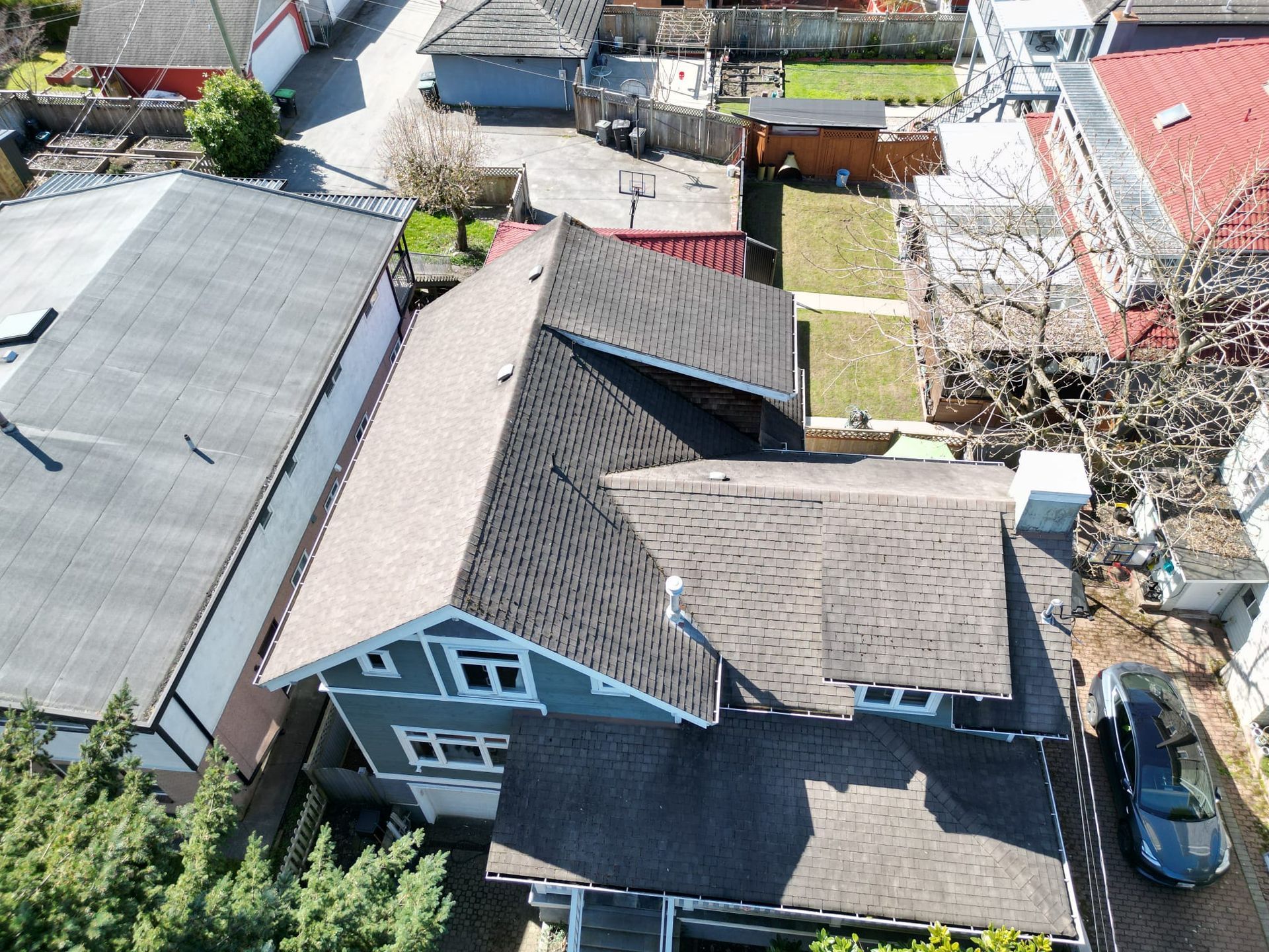 Side aerial of Vancouver character home roof before age-based replacement, hip and gable layout, Kensington-Cedar Cottage, Paragon Roofing BC