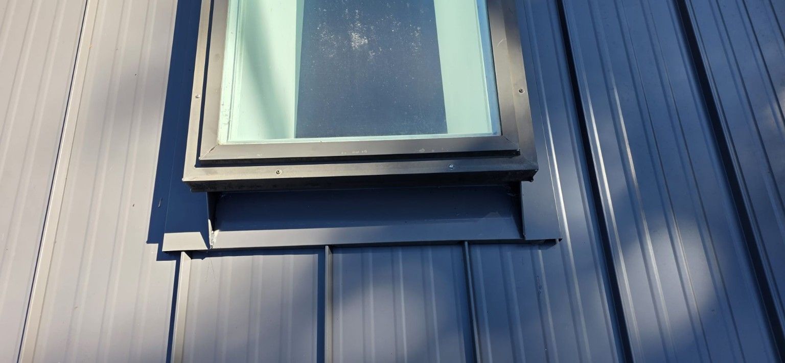Close view of metal flashing at the base and side of a skylight