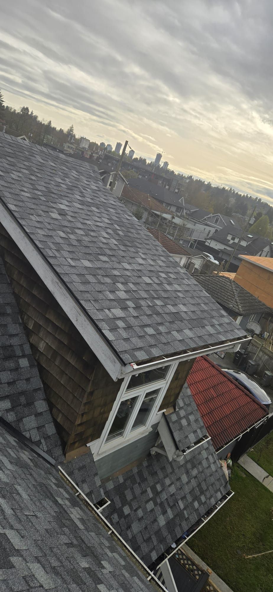 Completed roof with new IKO architectural shingles and Vancouver skyline, Prince Albert St, Paragon Roofing BC