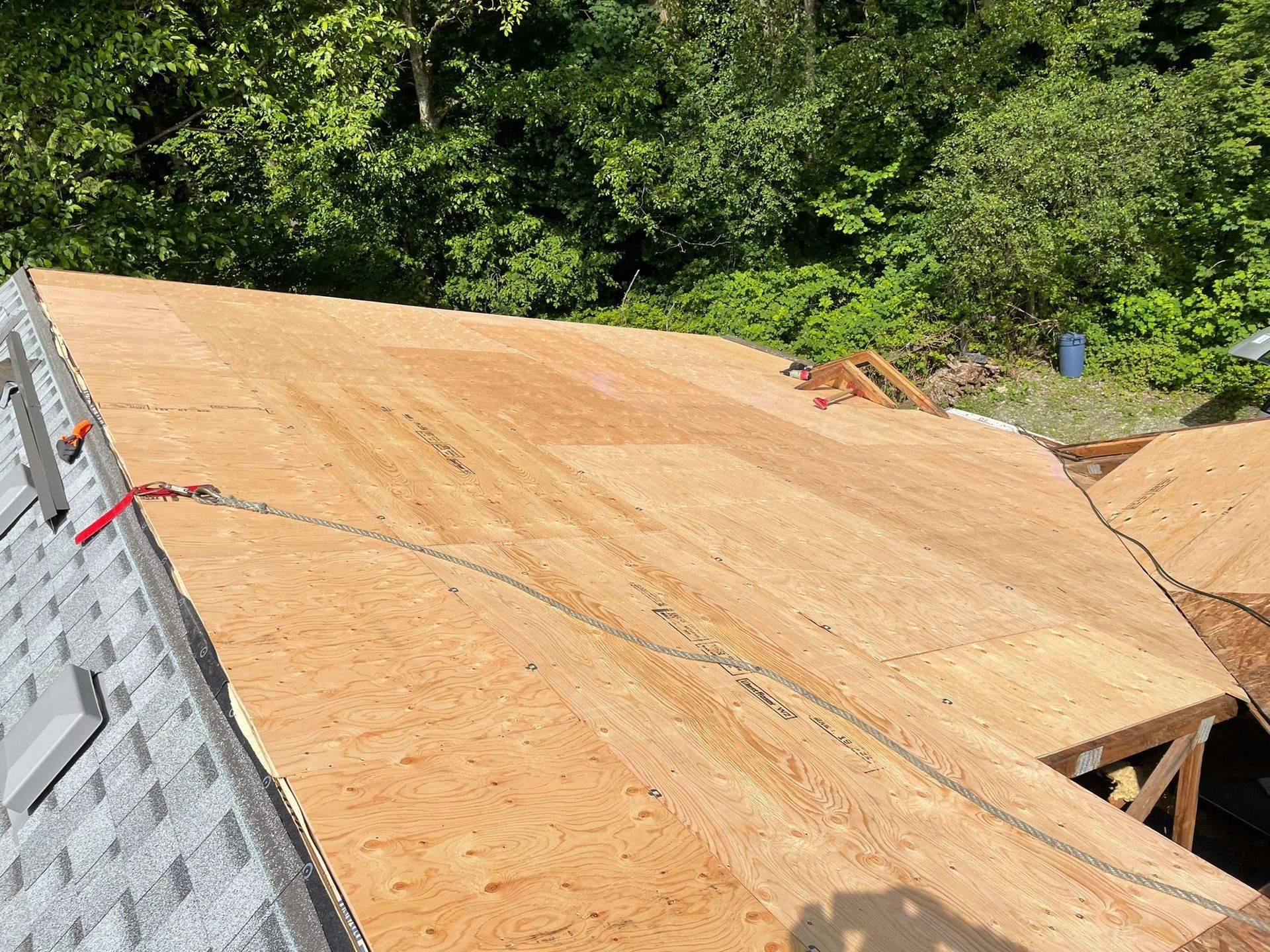 A roof is being built with plywood and shingles.