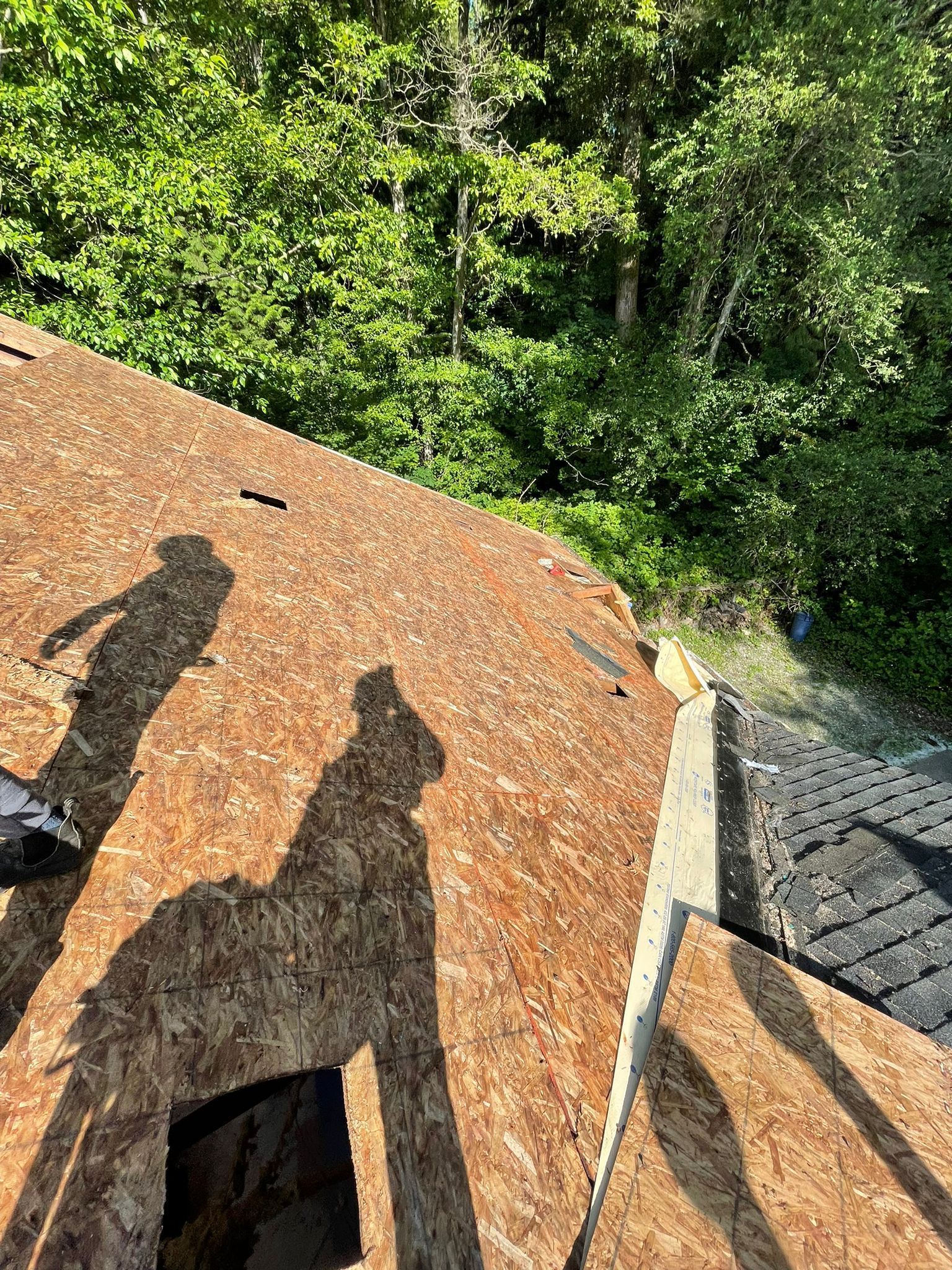 A close up of a roof with a shadow of a person on it.