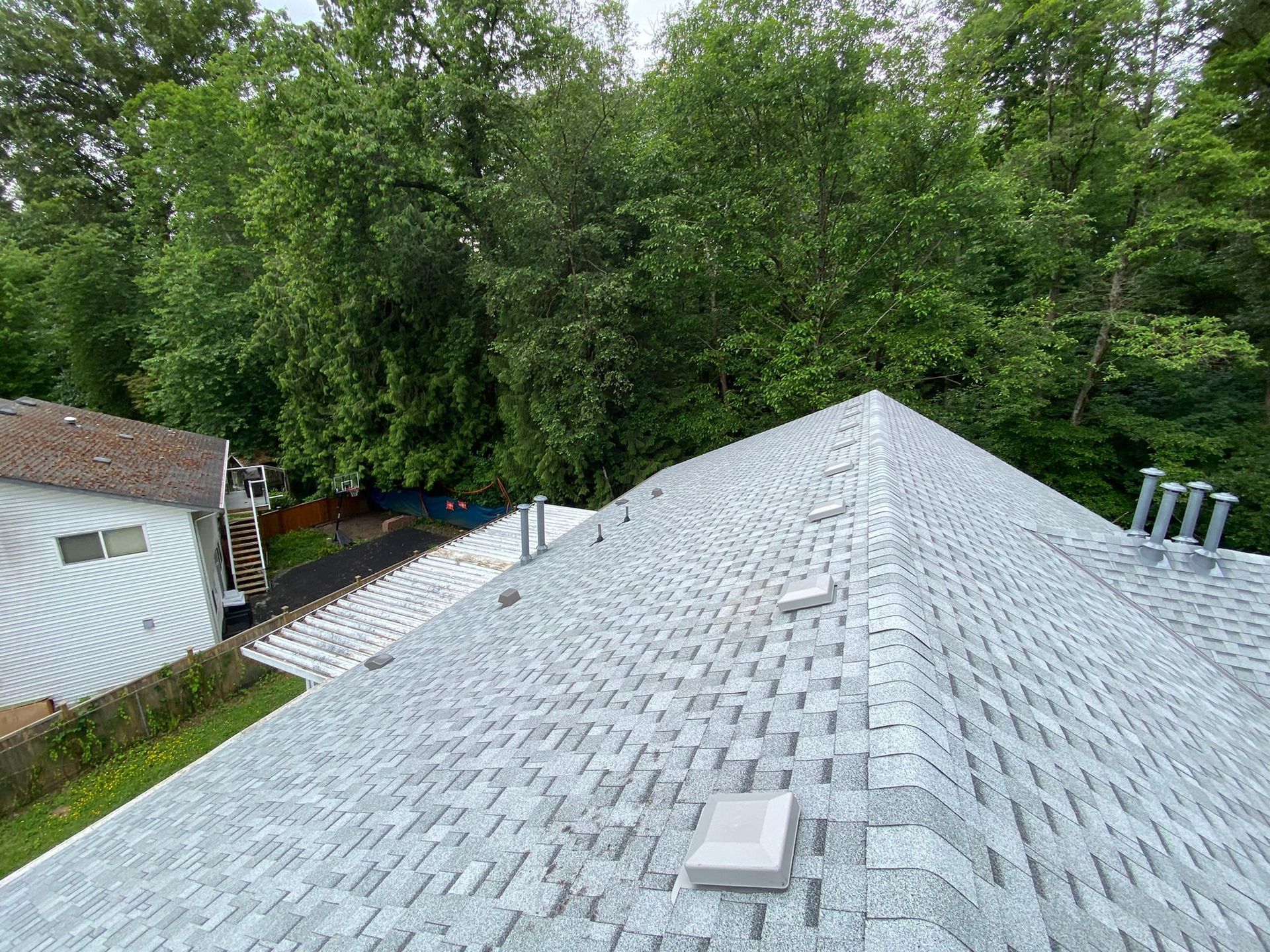 An aerial view of a roof with trees in the background.