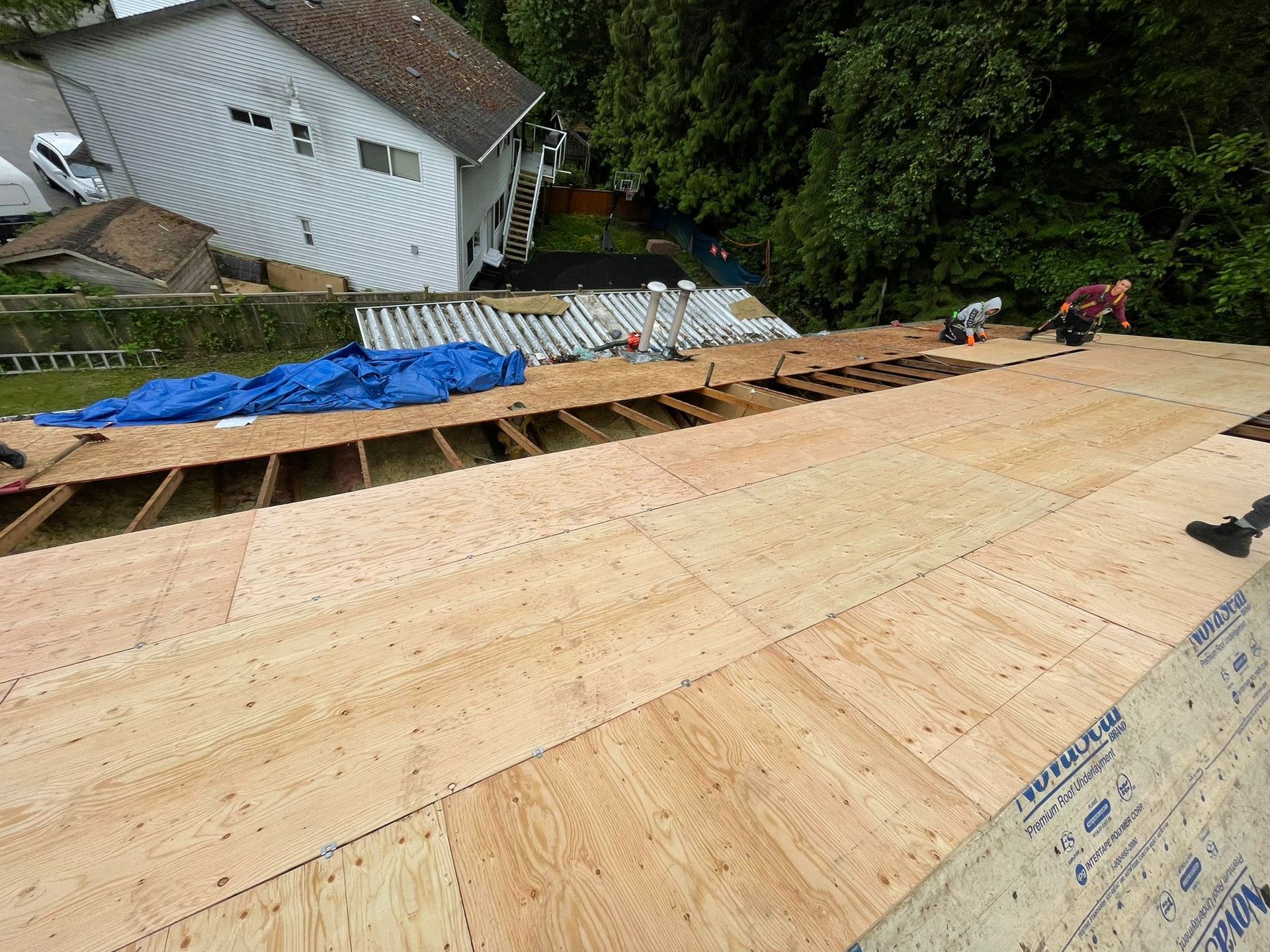 A man is working on the roof of a house.