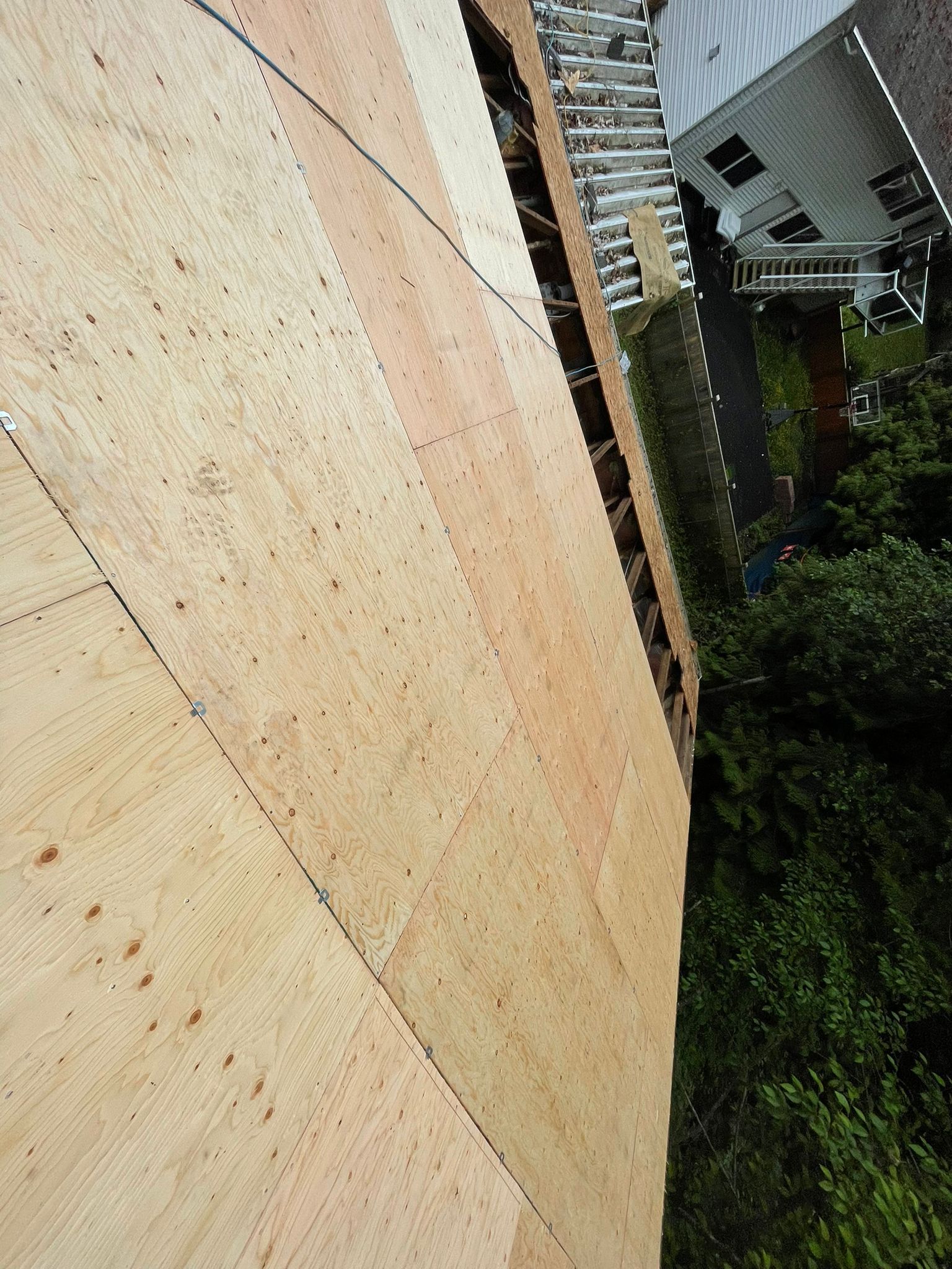 A large piece of plywood is sitting on top of a building.
