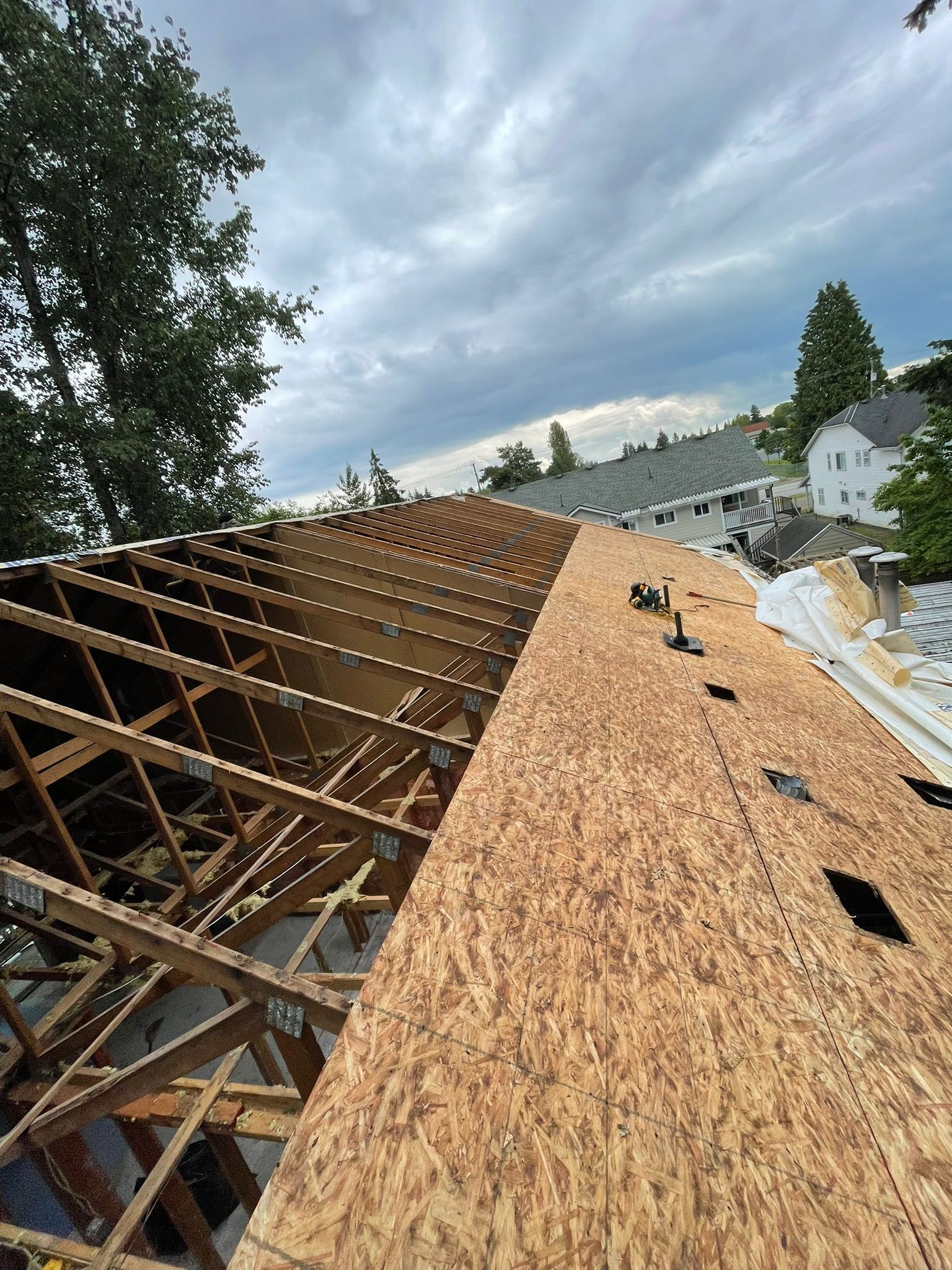A roof is being built with wooden beams and shingles.
