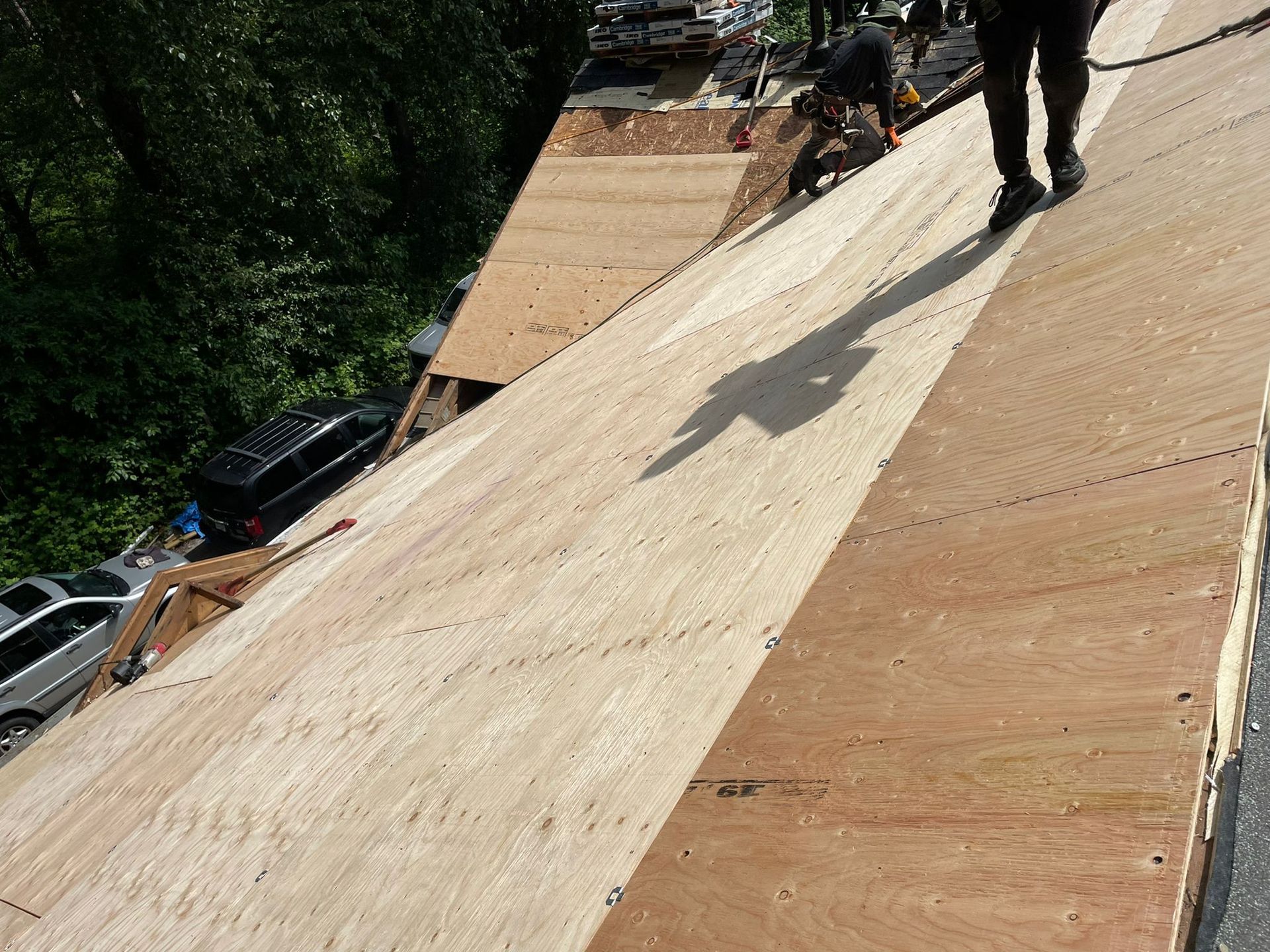 A man is standing on top of a wooden roof
