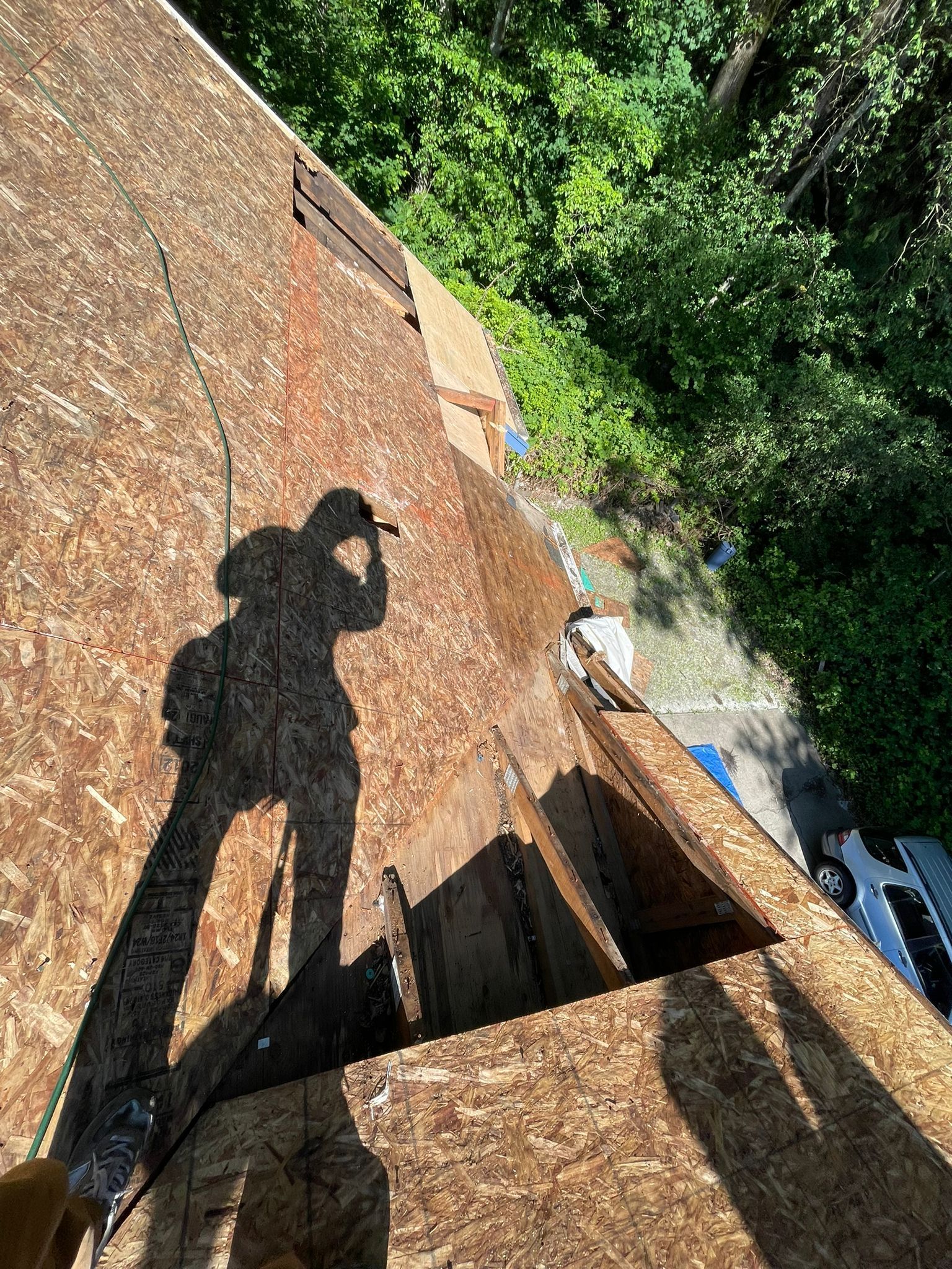 A shadow of a person is cast on a wooden roof.