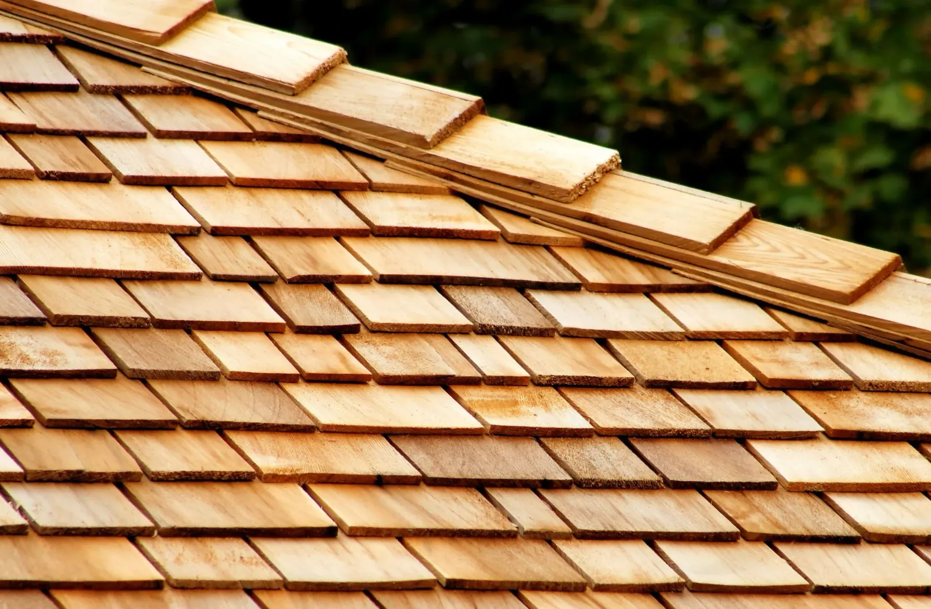 Close-up of a tan shingled roof with overlapping wooden tiles.