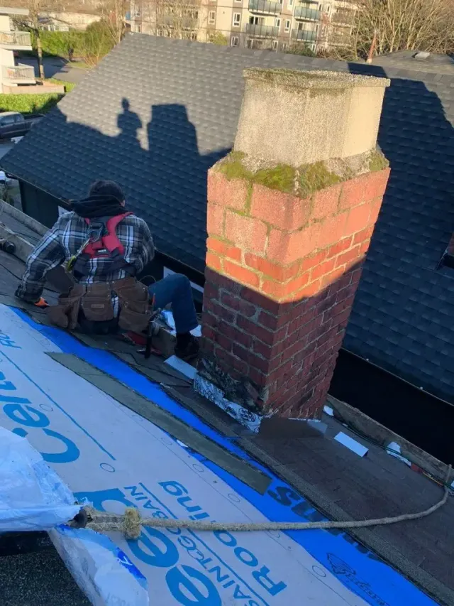Roofer working beside a chimney on the Triumph Street roof