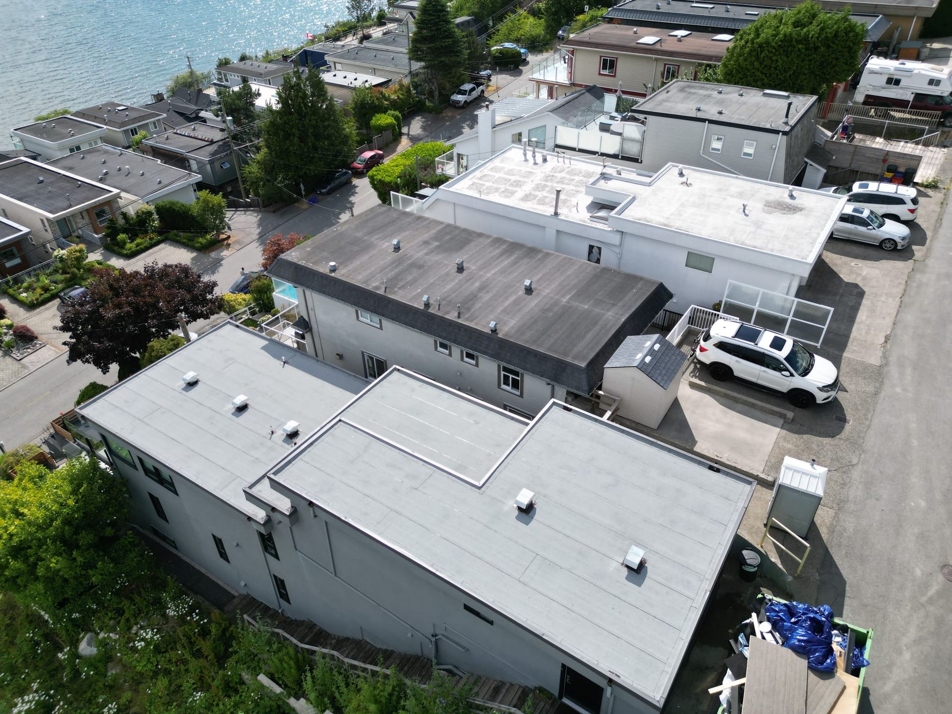 Aerial view of a flat membrane roof with vents and raised roof edges