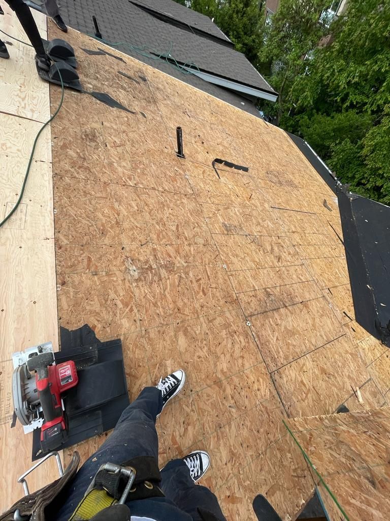 A person is working on a roof with a circular saw.