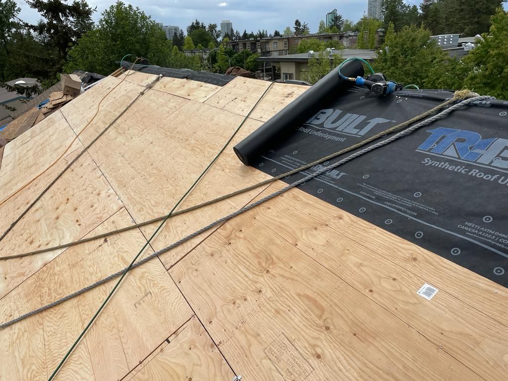 A roof is being built with plywood and a roll of roofing material.