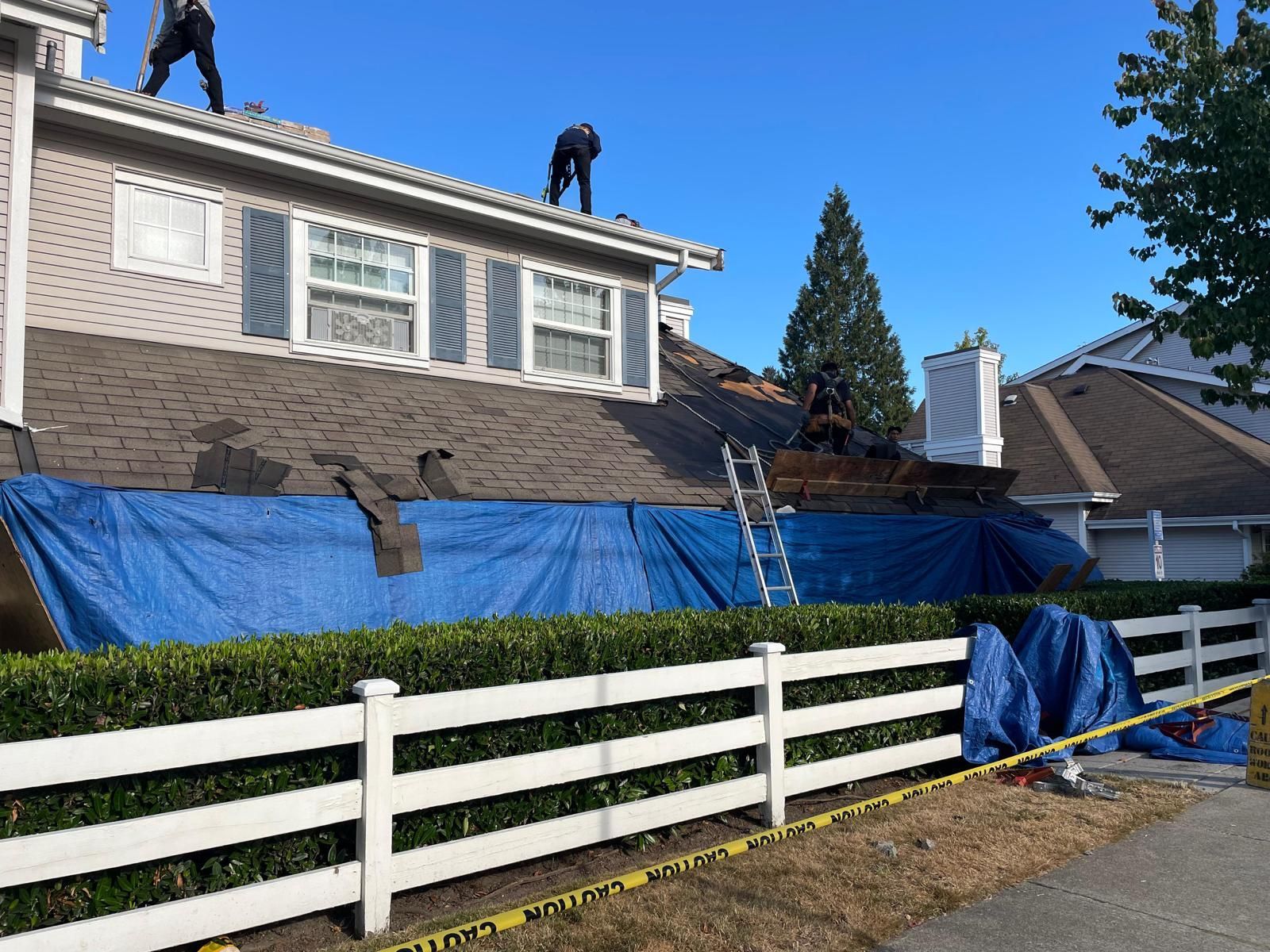 Two men are working on the roof of a house.