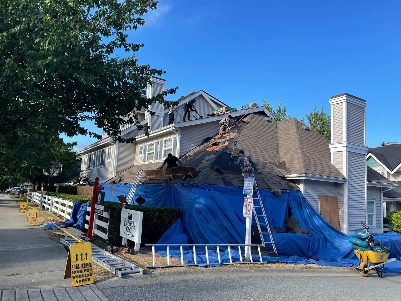 A house is being remodeled with a blue tarp covering the roof.