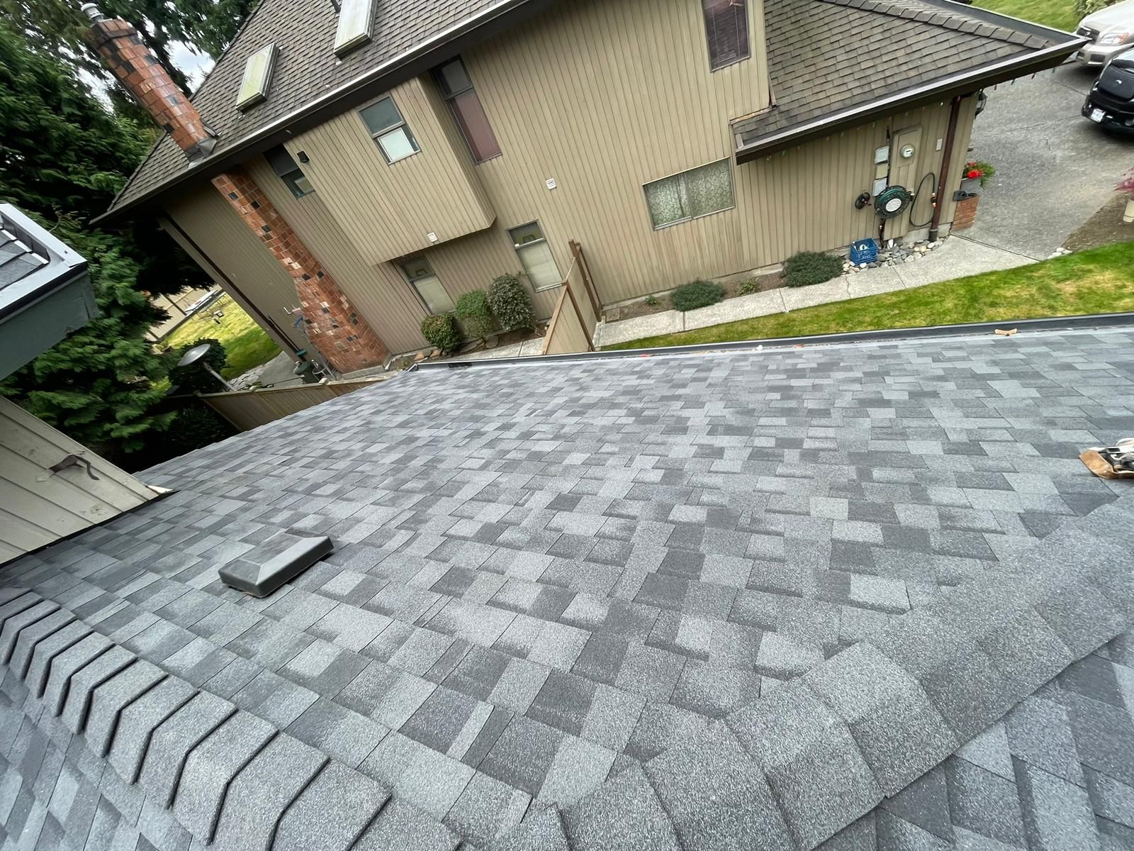 A close up of a roof with a house in the background.