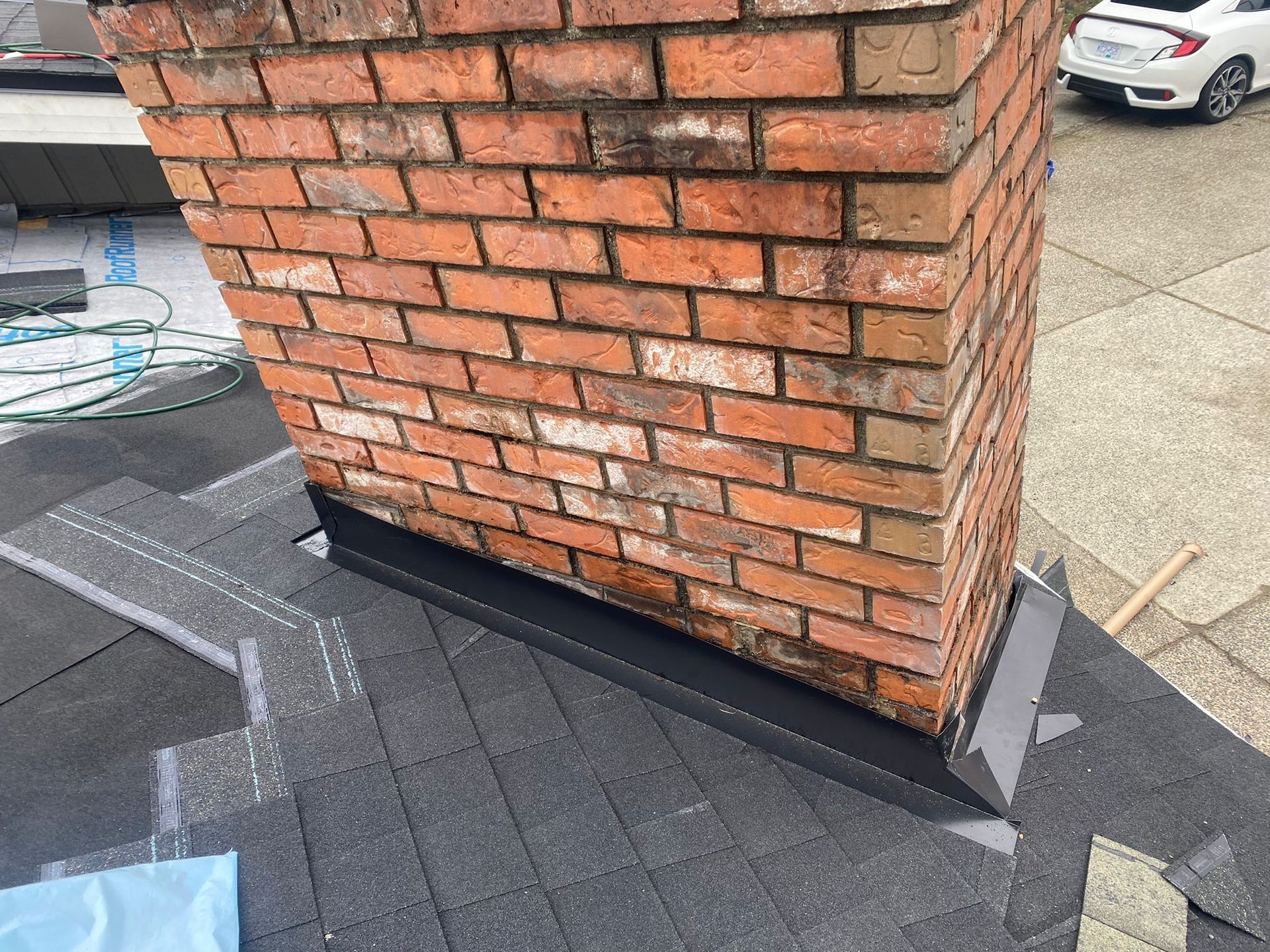 A brick chimney is sitting on top of a roof.