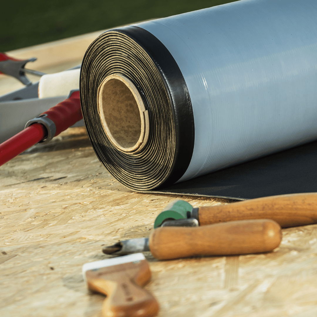 A roll of roofing material and tools on a table