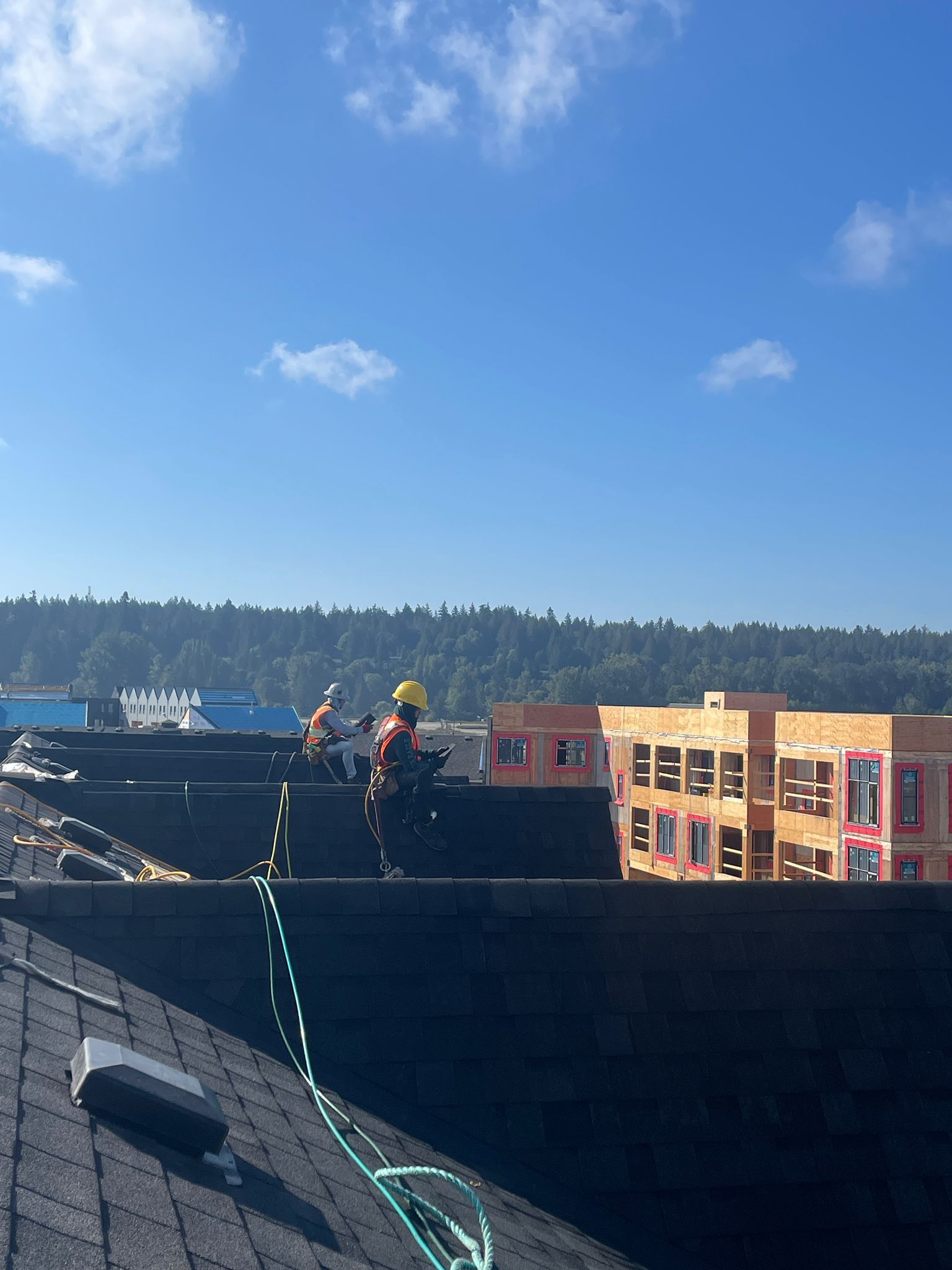 A man is working on the roof of a building on a sunny day. coquitlam roofing