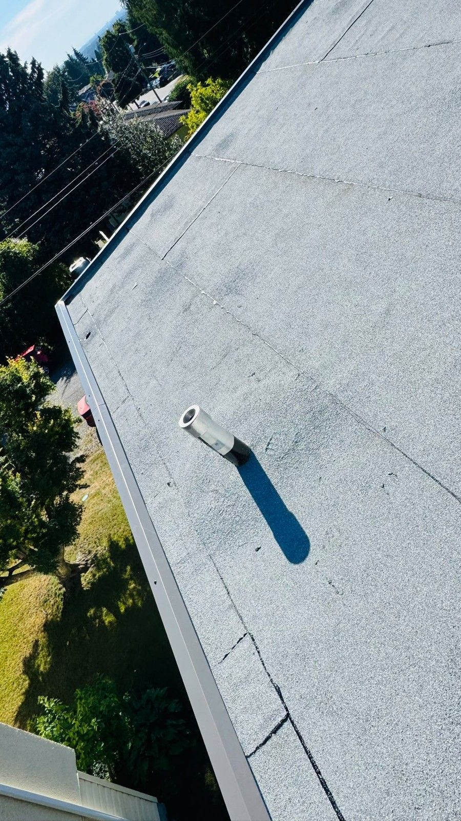 Granule surfaced membrane at metal edge flashing with a pipe penetration