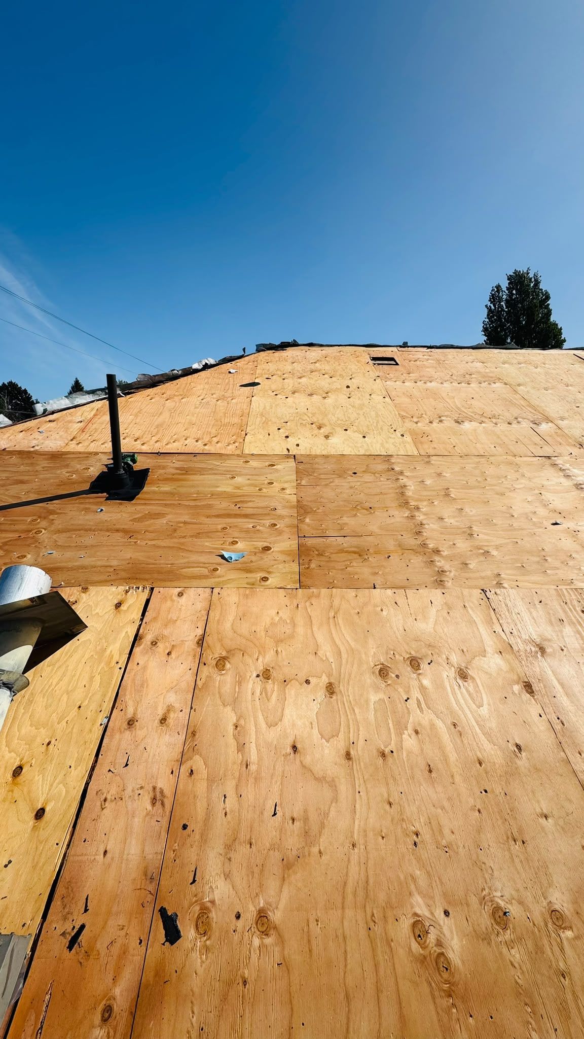 Exposed plywood roof deck with a pipe penetration, metal duct and roof opening
