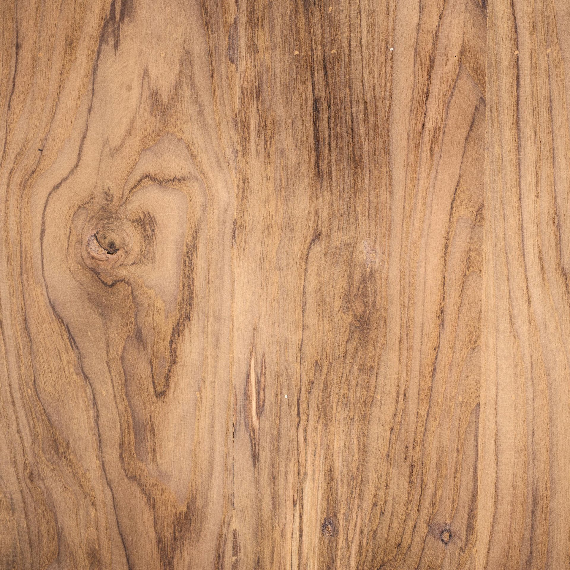 A high-resolution close-up of light brown wood grain featuring natural streaks, patterns, and a prominent knot.