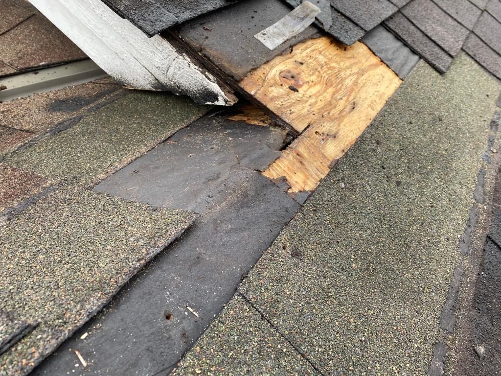 A close up of a roof with a hole in it. commercial roof repair service near me