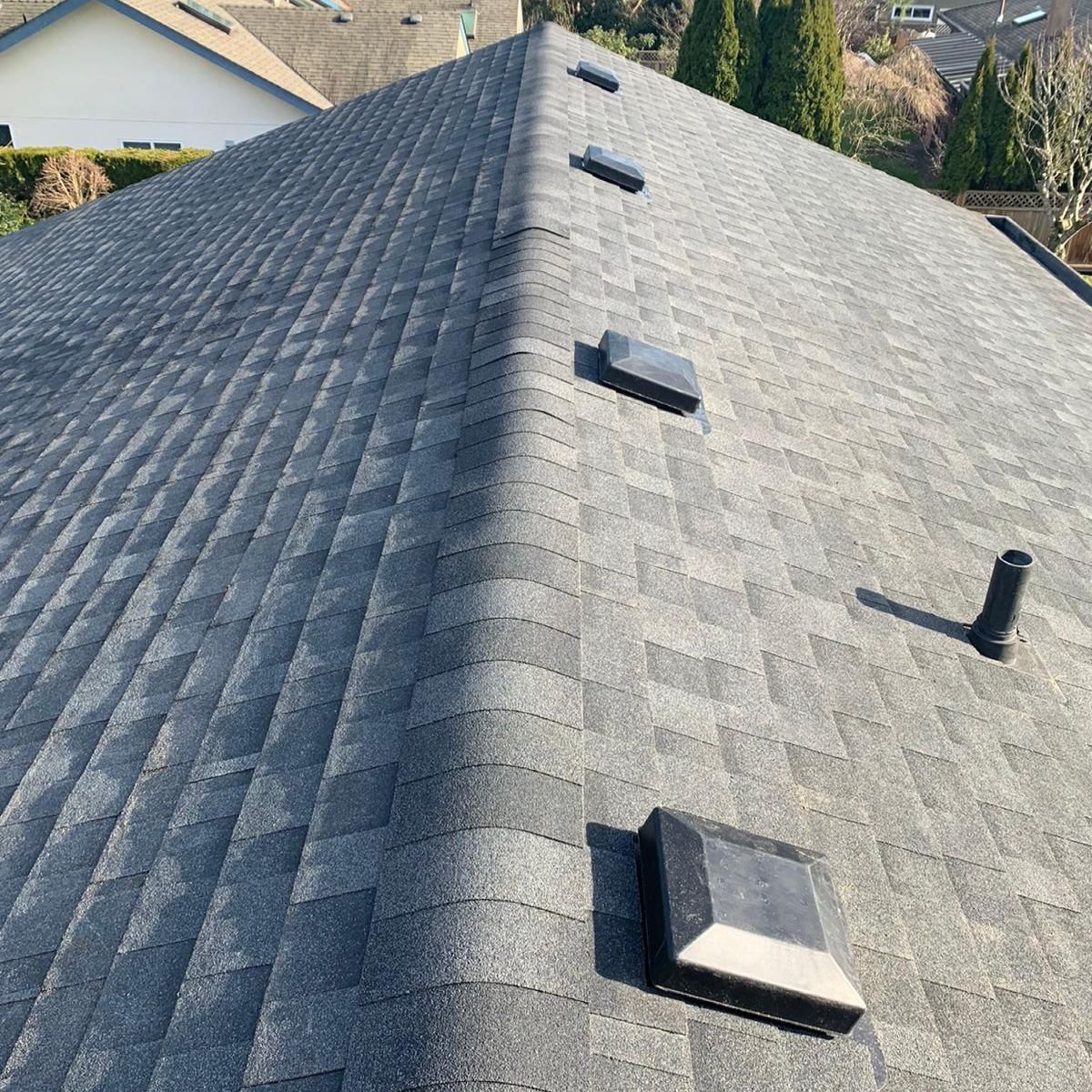 A roof with a lot of shingles and vents on it.