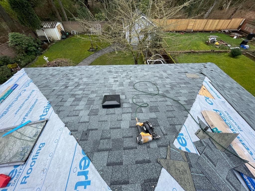 An aerial view of a roof with shingles being installed.