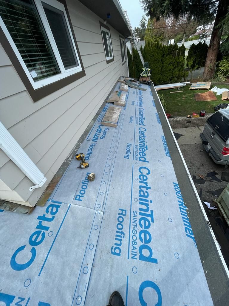 An overhanging roof is being installed on the side of a house.
