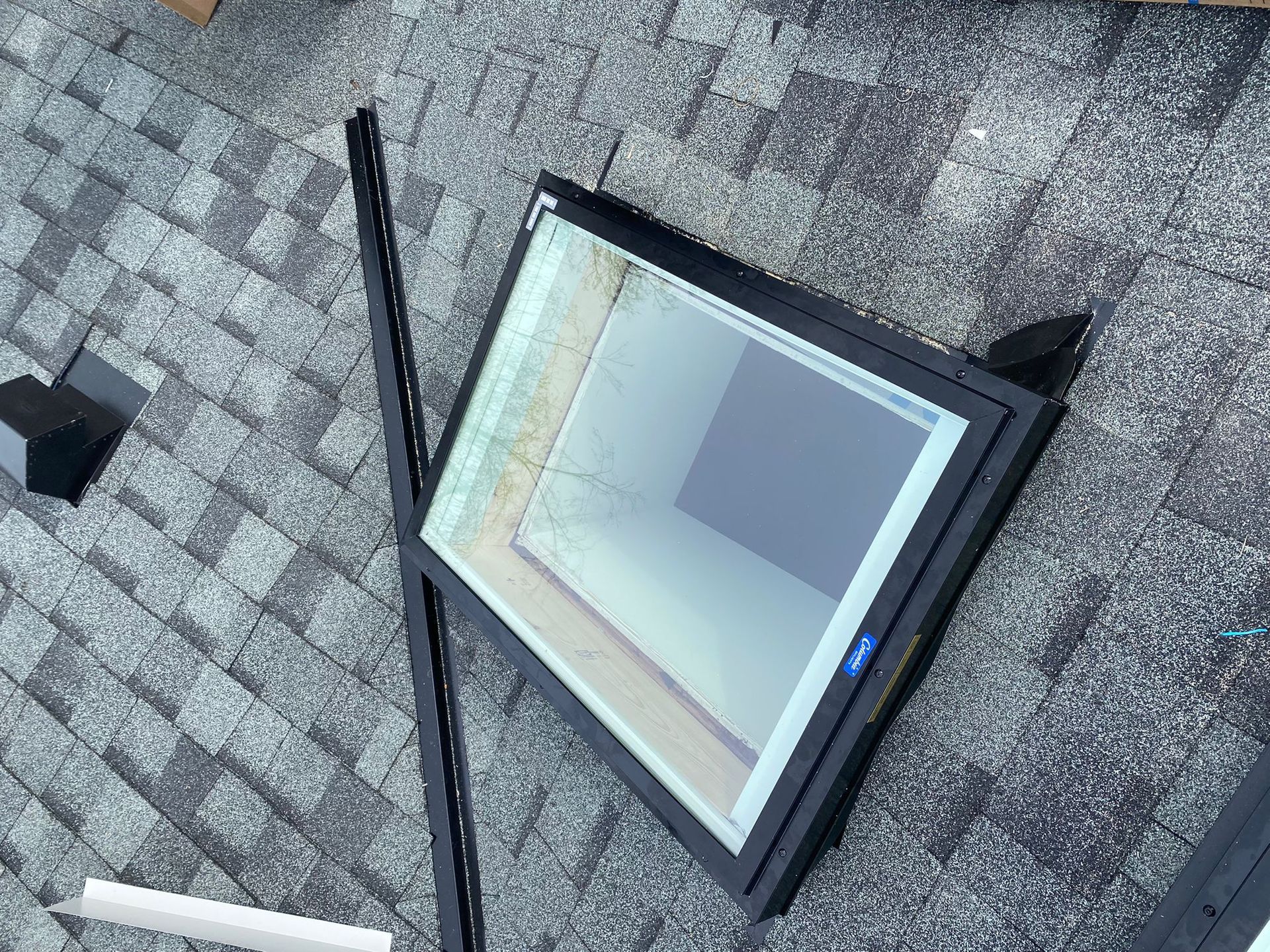 A skylight is sitting on top of a roof.